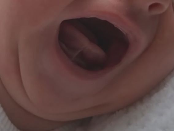 a close up of a baby 's mouth with its tongue sticking out