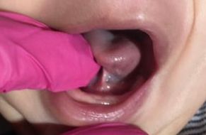 a close up of a baby's mouth with its tongue sticking out