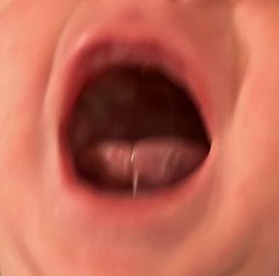 a close up of a baby 's mouth with its tongue sticking out .