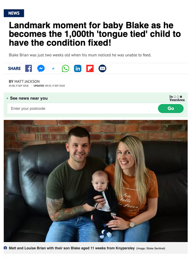 a man and woman are sitting on a couch holding a baby 