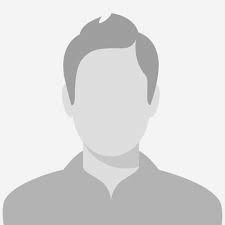 Tannlege Christian med briller og skjegg, iført blå skjorte og medisinsk maske, smiler til kameraet.