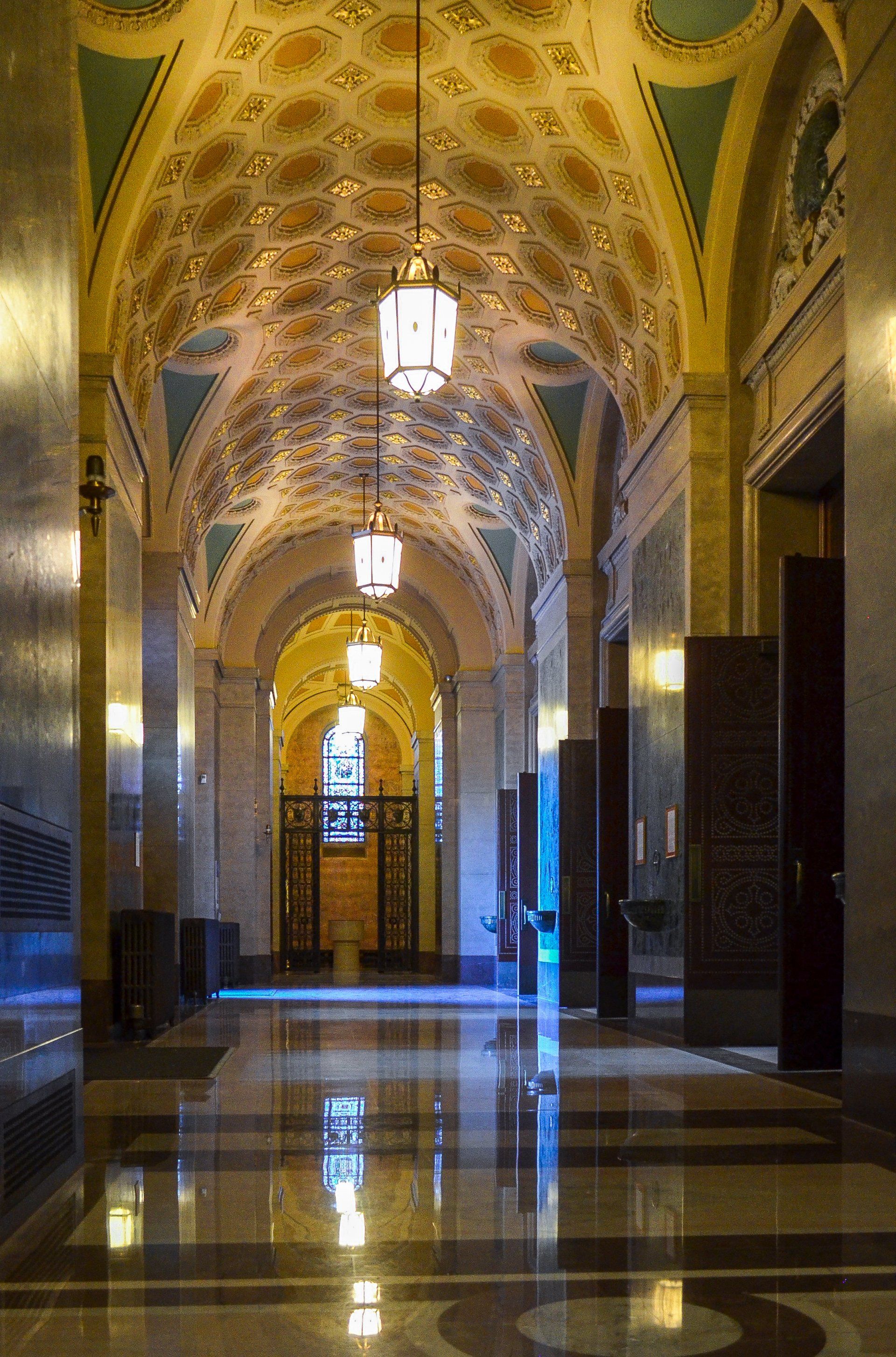 A hallway in a building with a ceiling that is very ornate