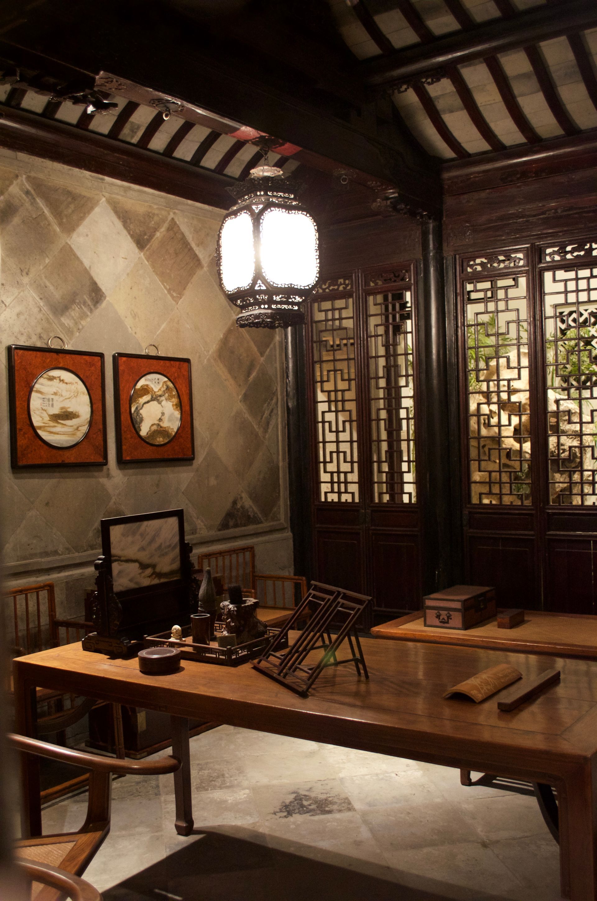 A room with a table and chairs and a lantern hanging from the ceiling