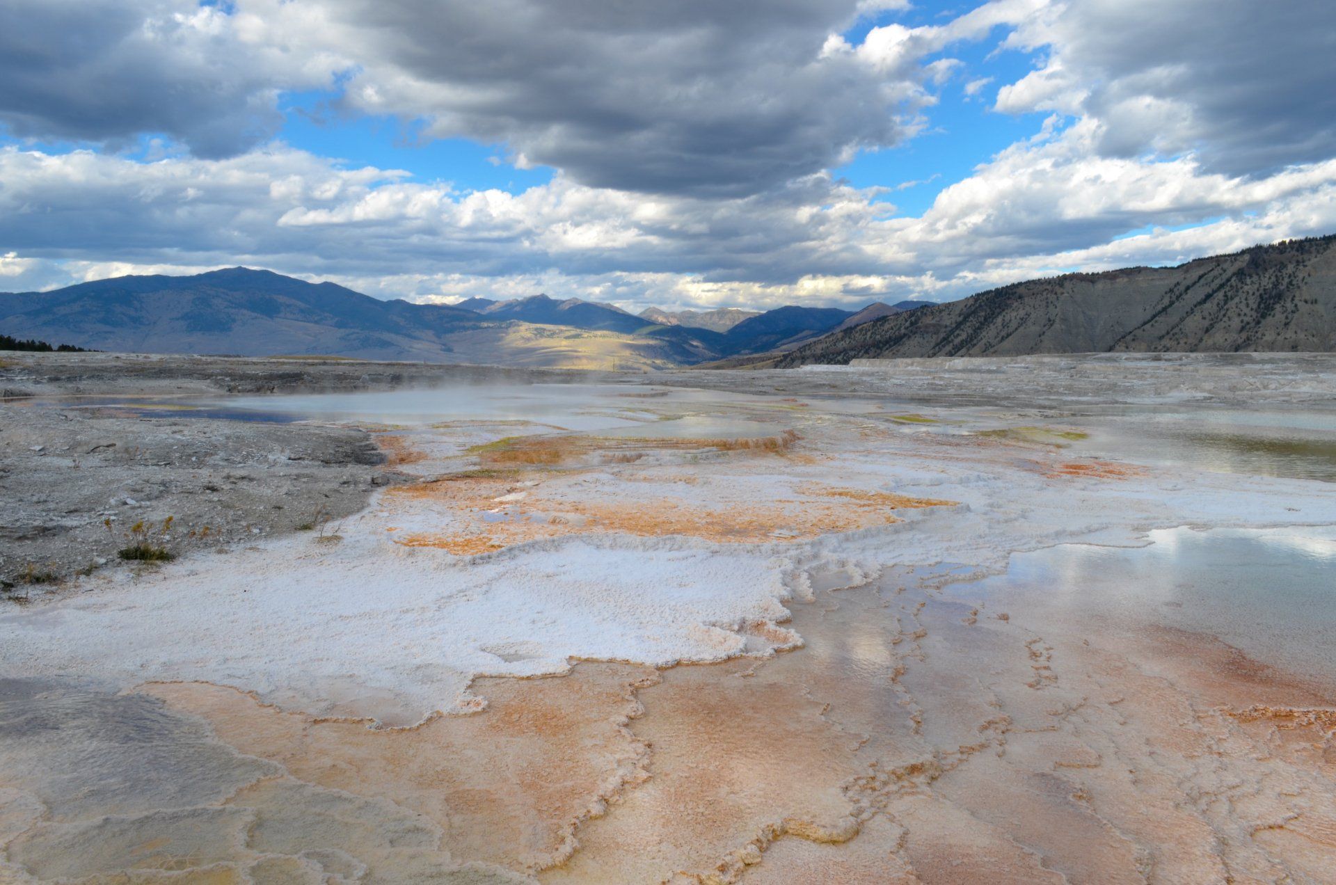 A desert landscape with mountains and clouds in the background