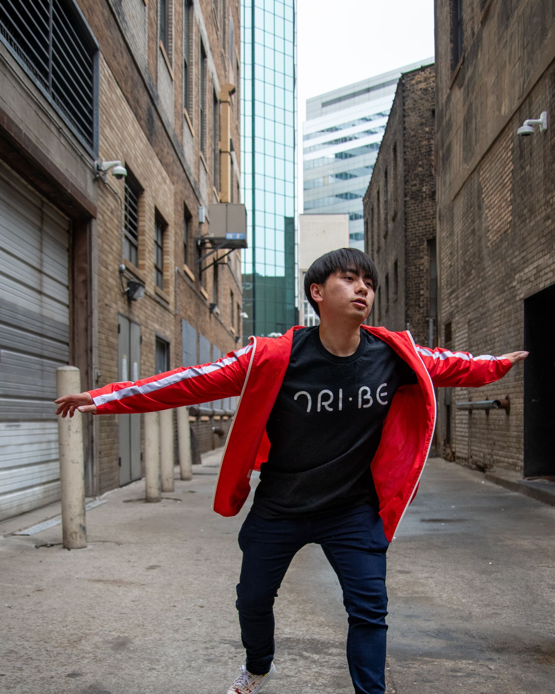 A young man wearing a black shirt that says tri-be