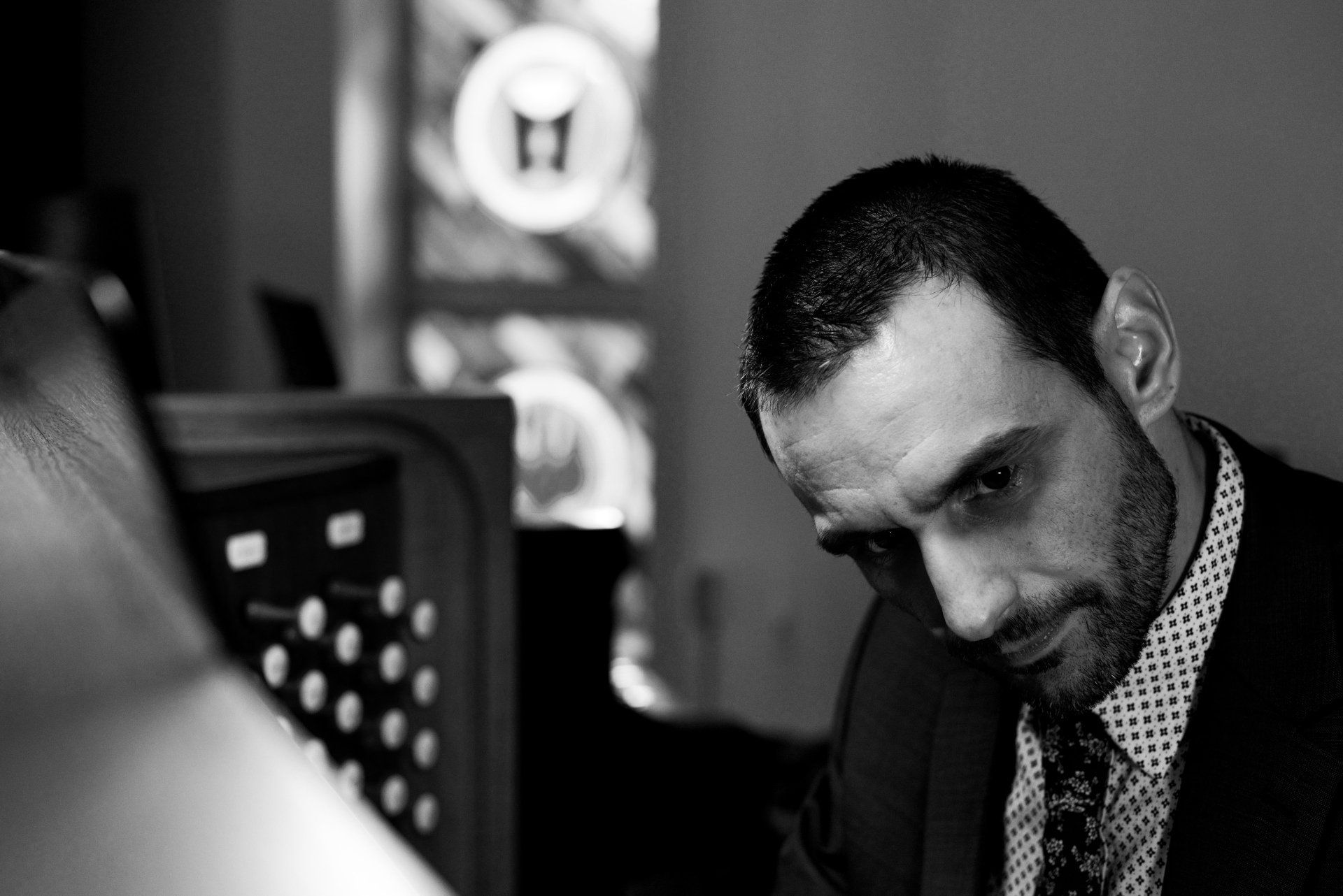 A man in a suit and tie is looking down at something