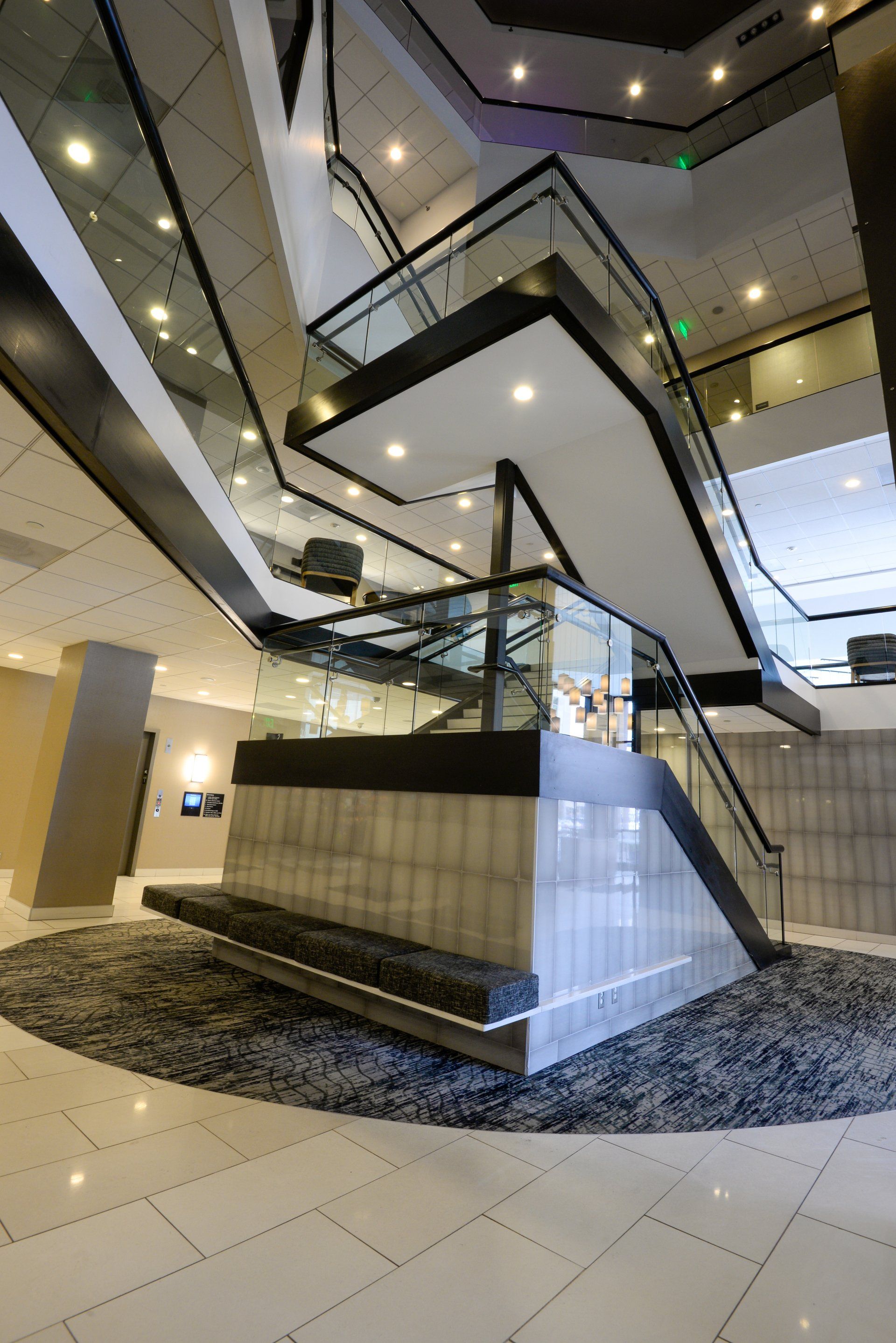 A large staircase in a building with a green exit sign