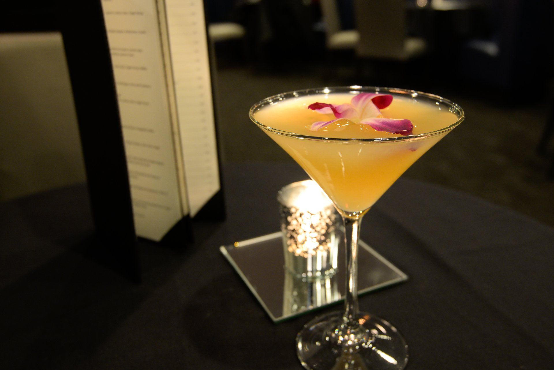 A martini with flowers in it sits on a table