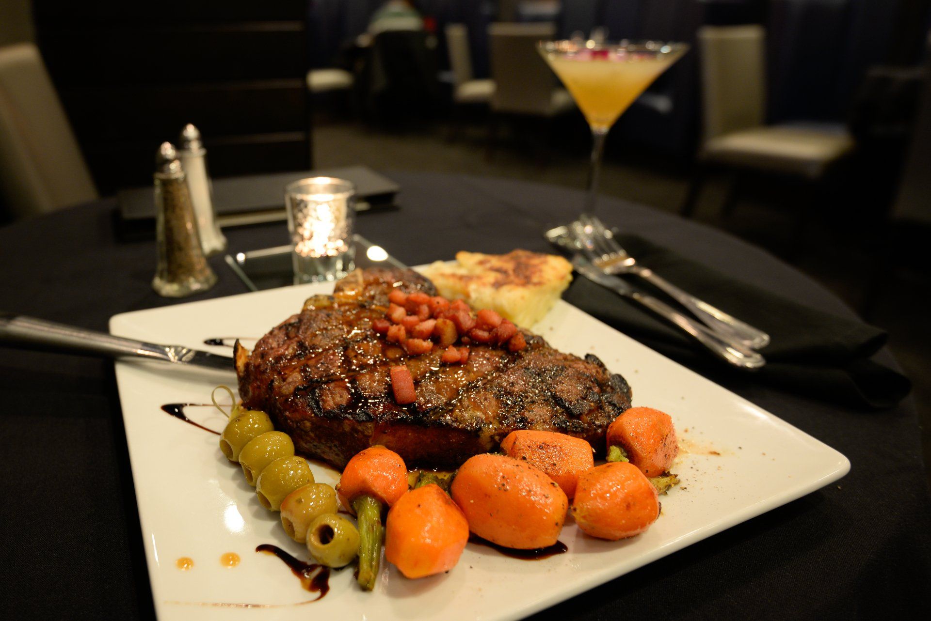 A white plate with a steak and vegetables on it