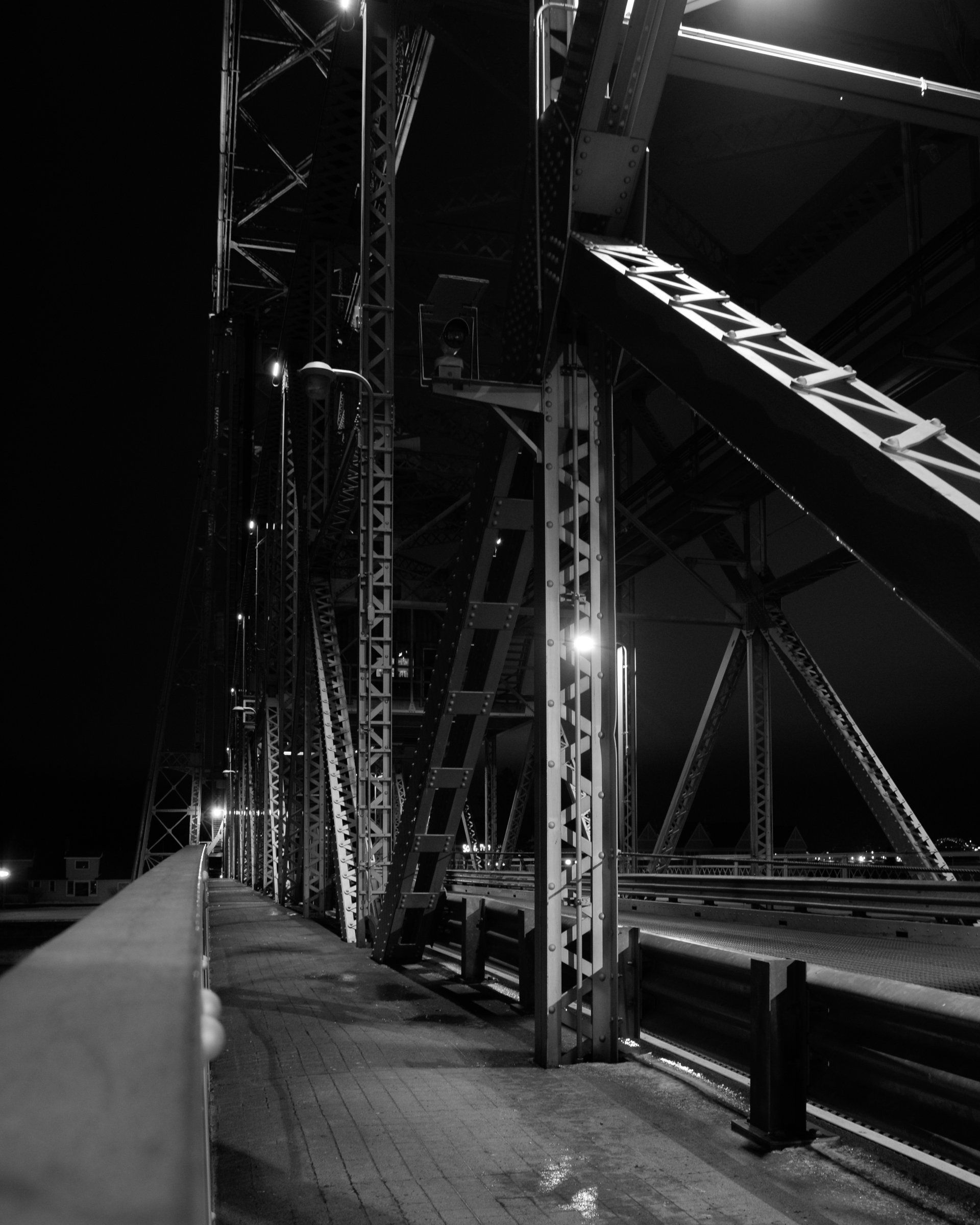 A black and white photo of a bridge at night