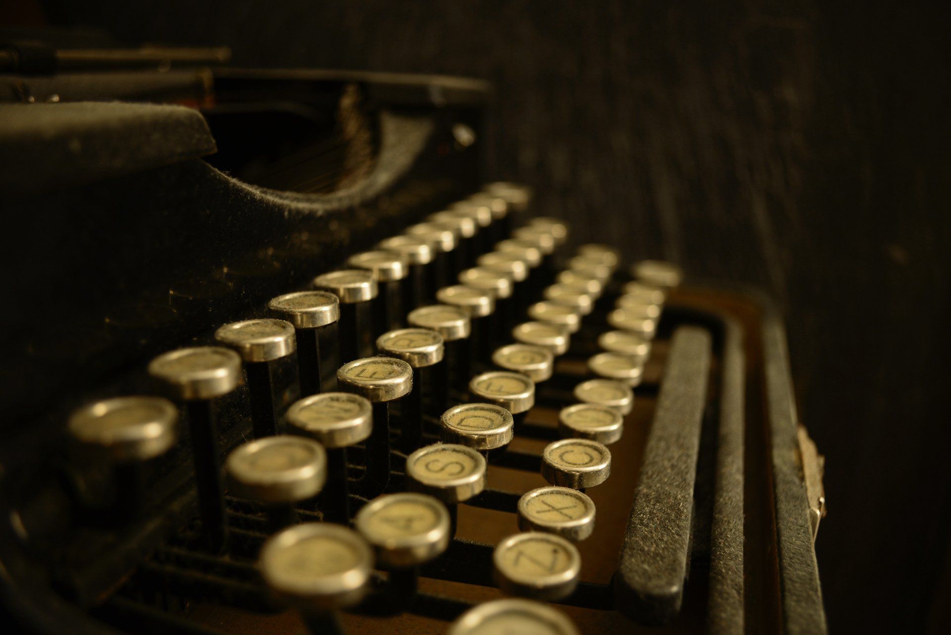 A close up of an old typewriter with a few keys missing