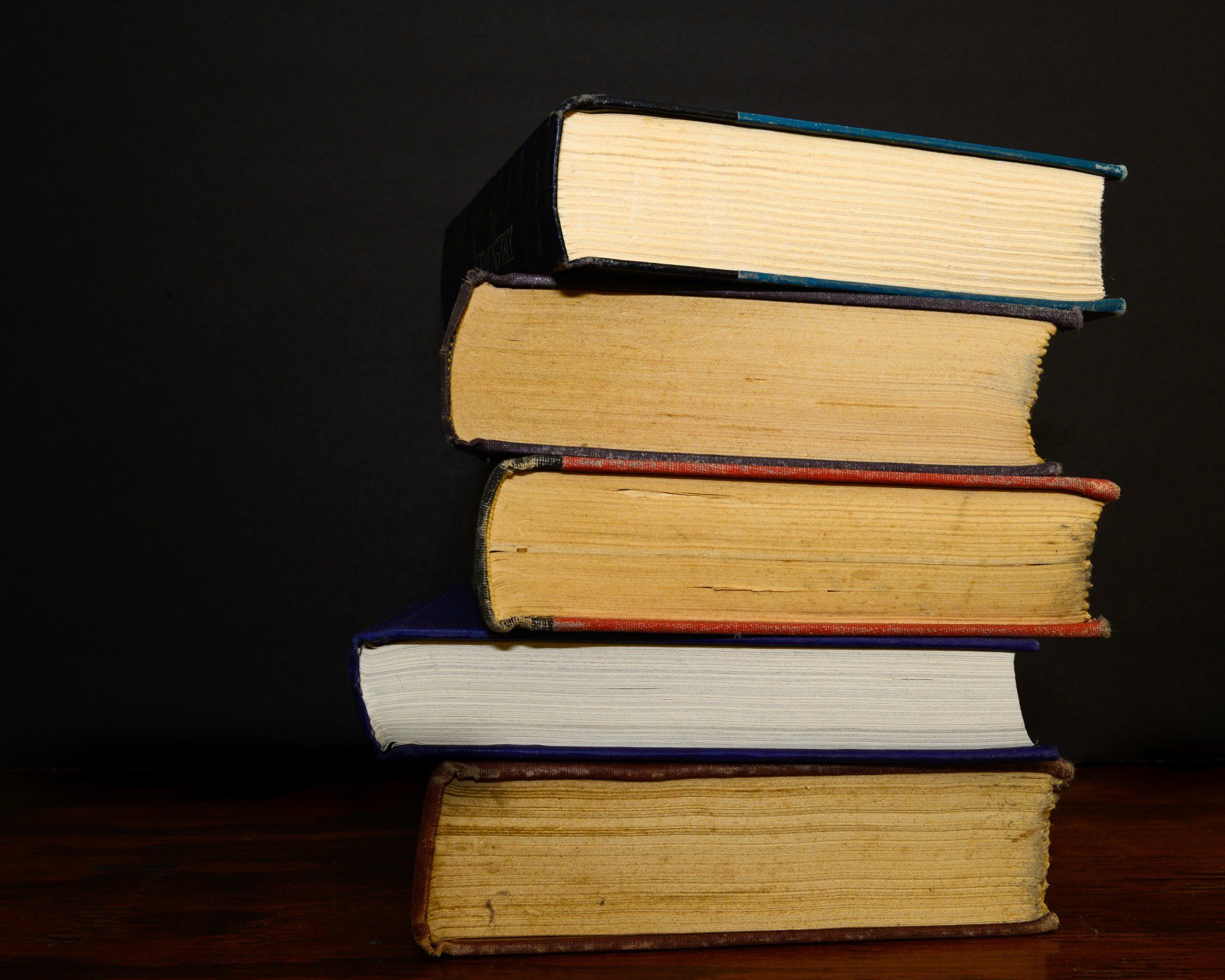 A stack of books on a table with a black background