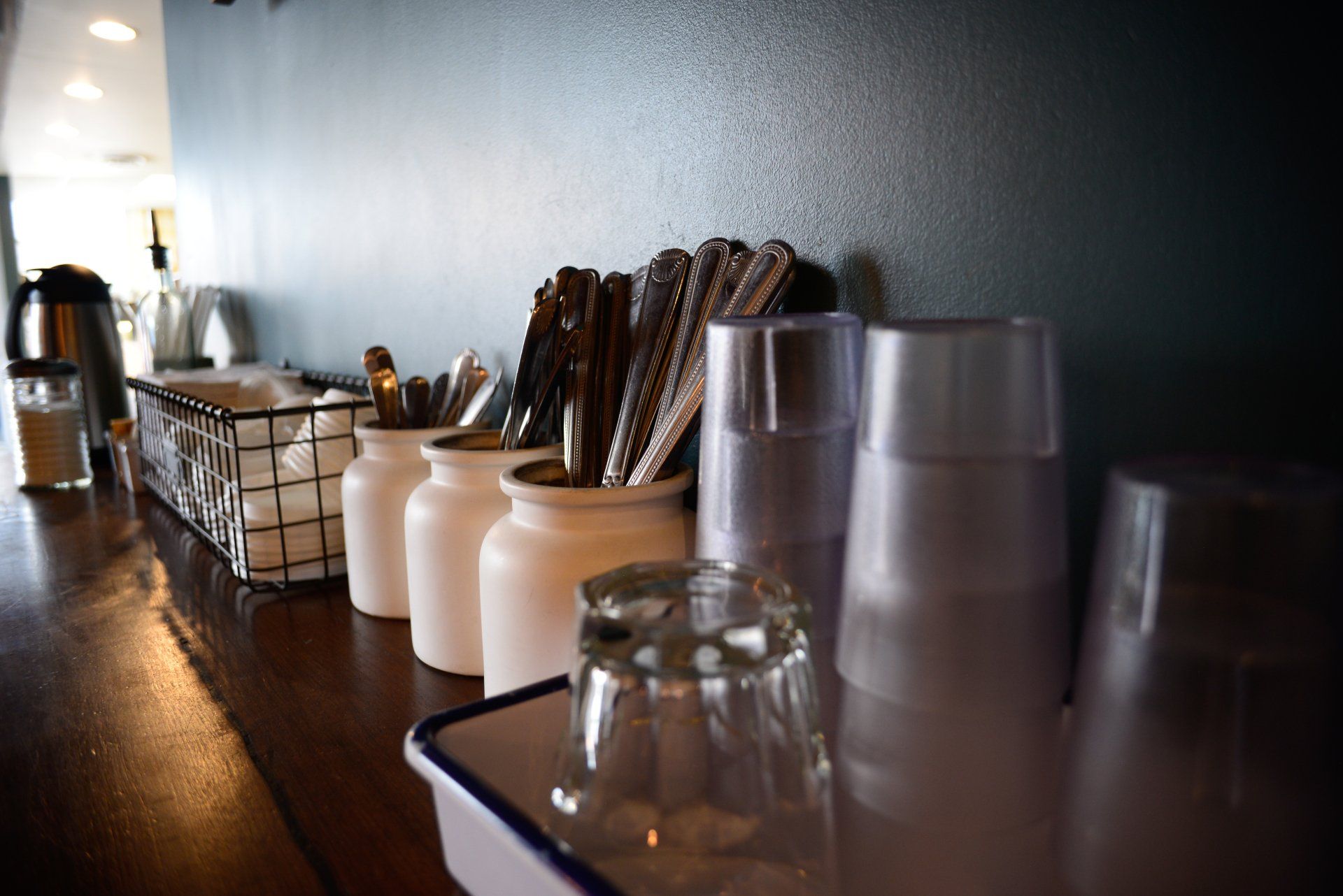 A row of glasses and utensils on a counter