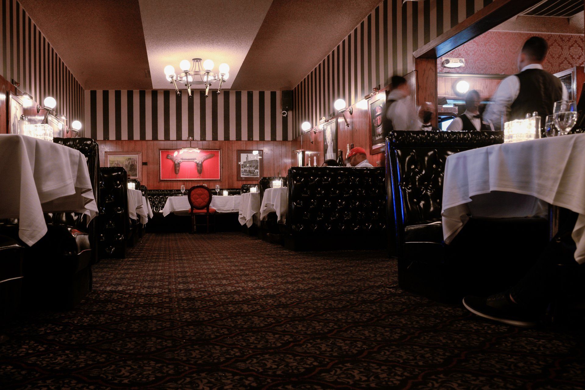 A restaurant with striped walls and tables and chairs