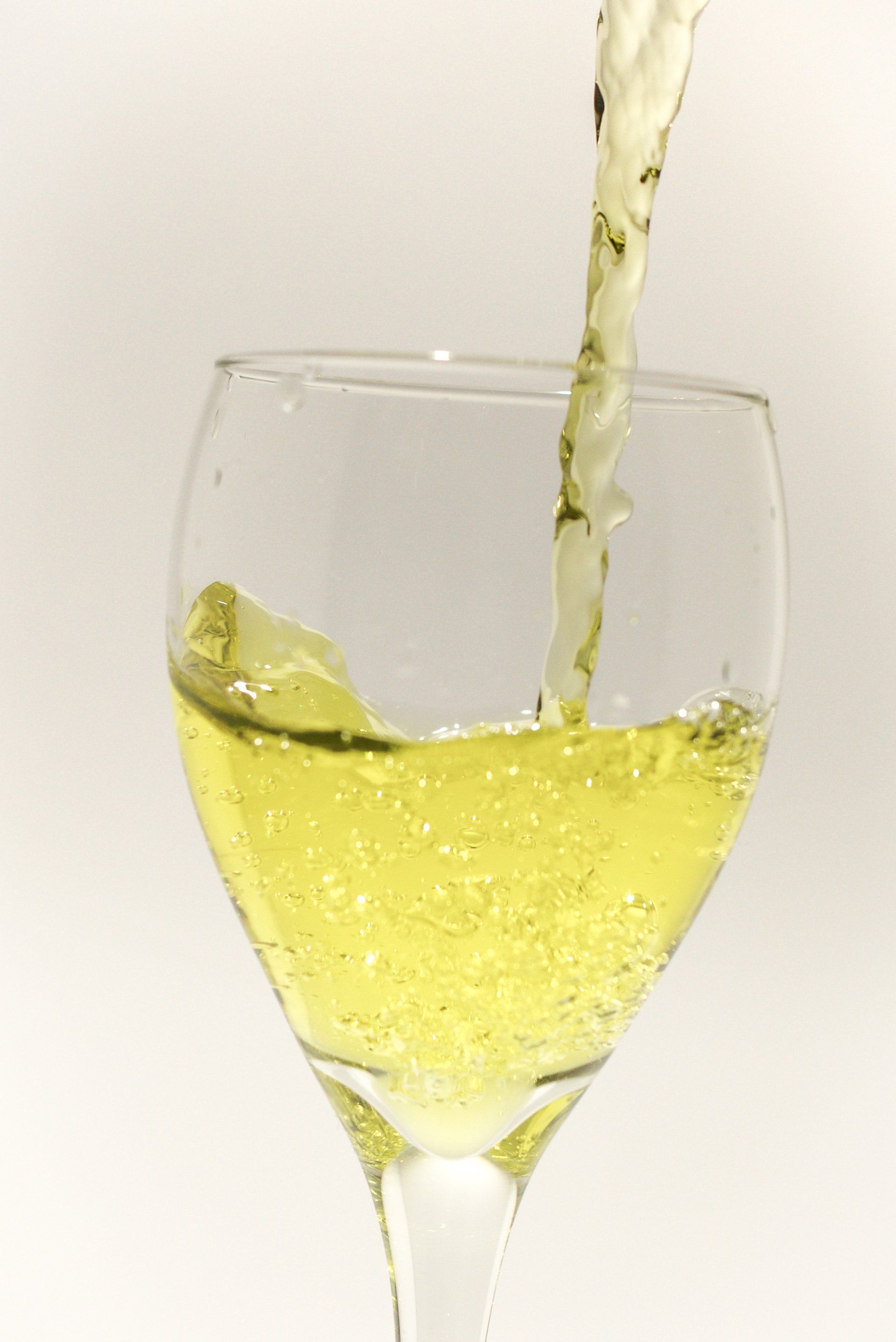 A glass of yellow liquid is being poured into it