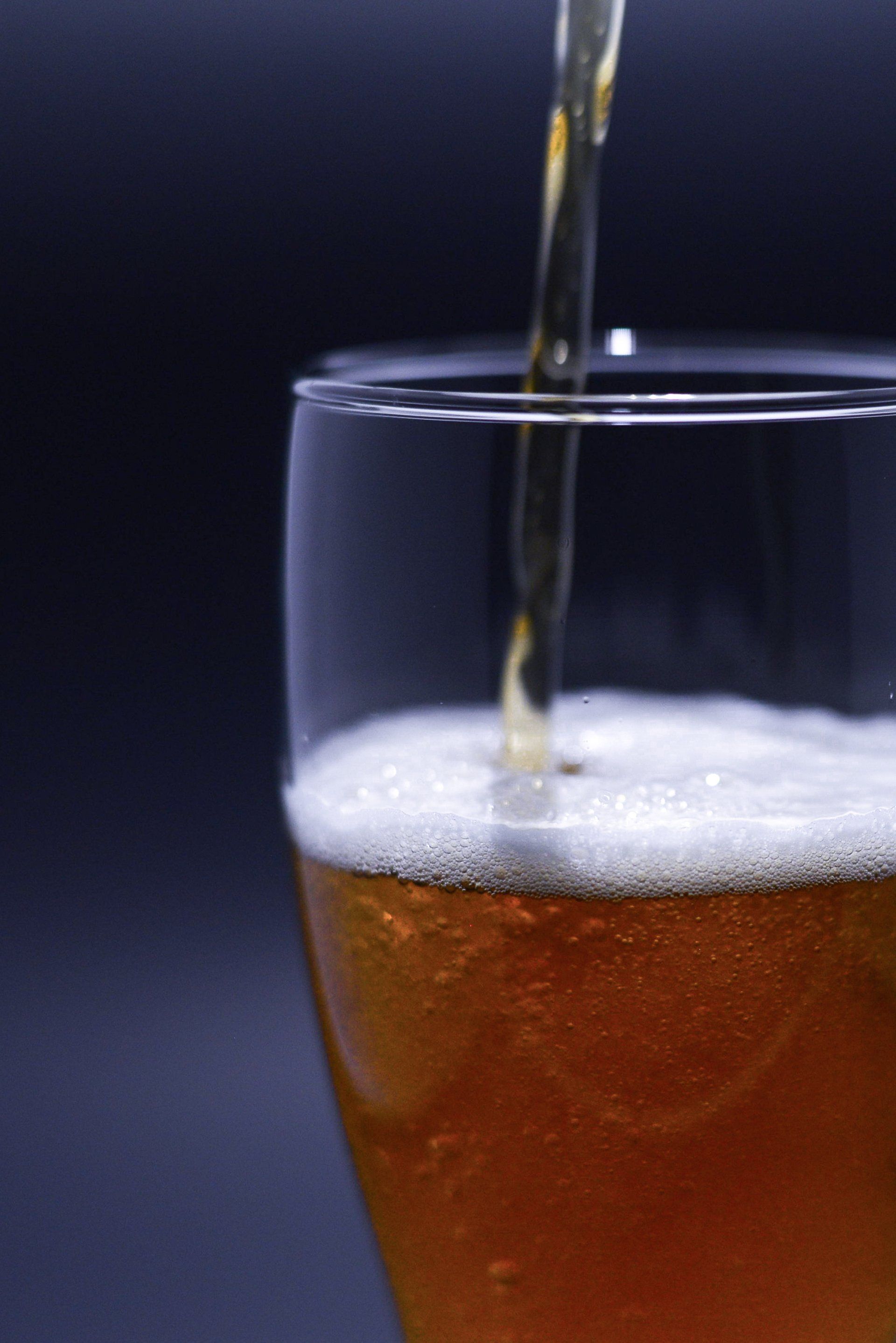 A glass of beer is being poured into it