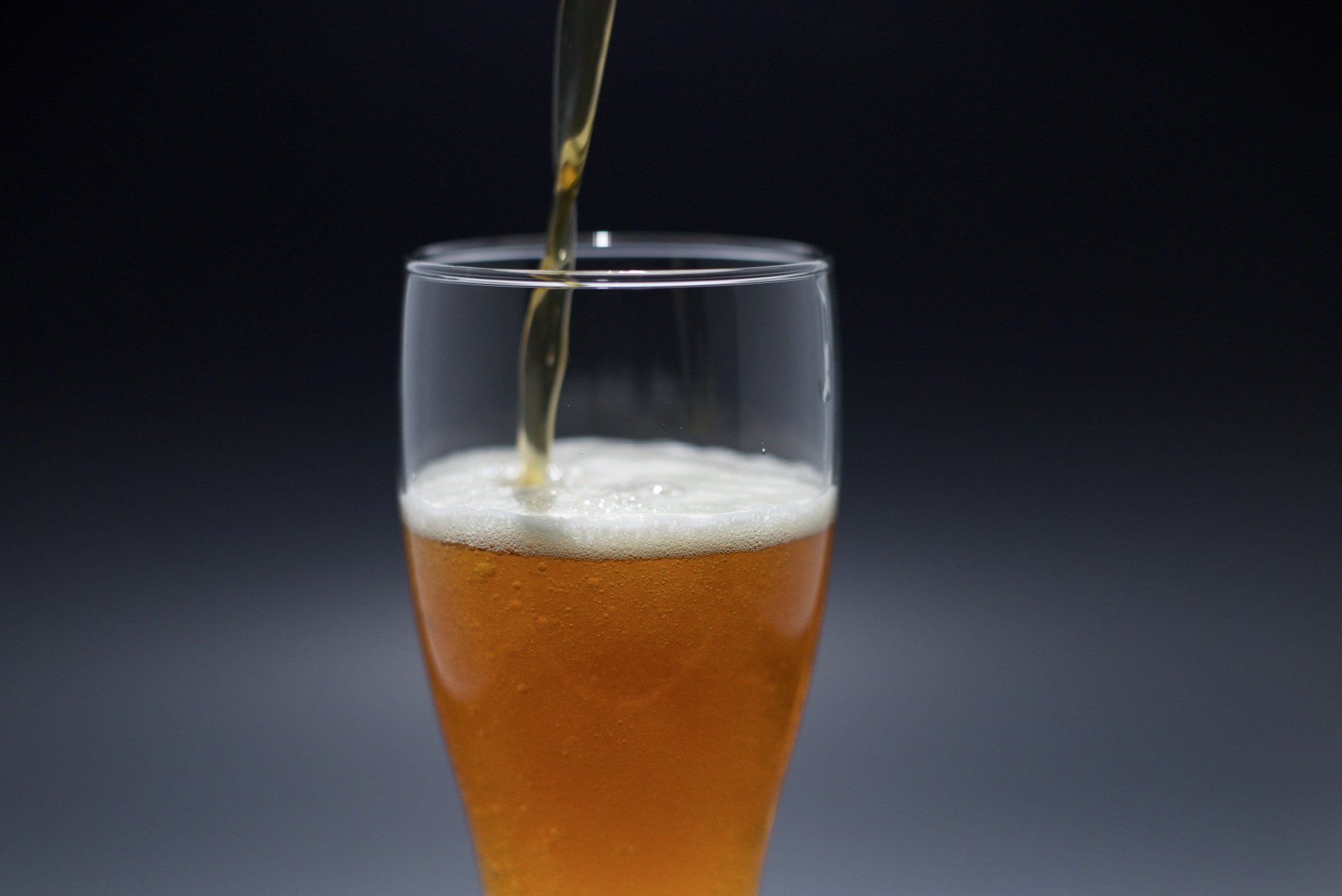 A glass of beer is being poured into a glass.