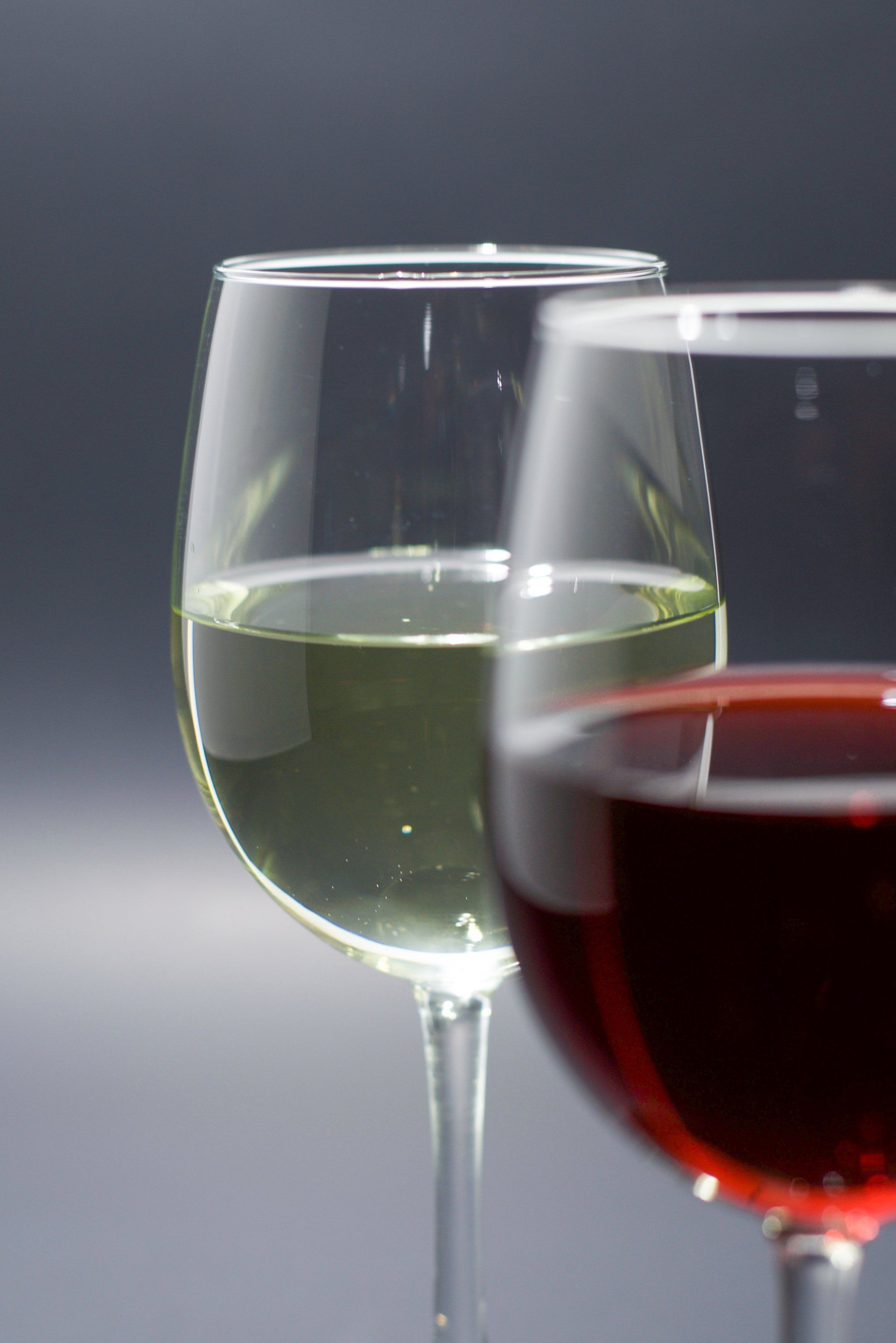 A glass of red wine sits next to a glass of white wine