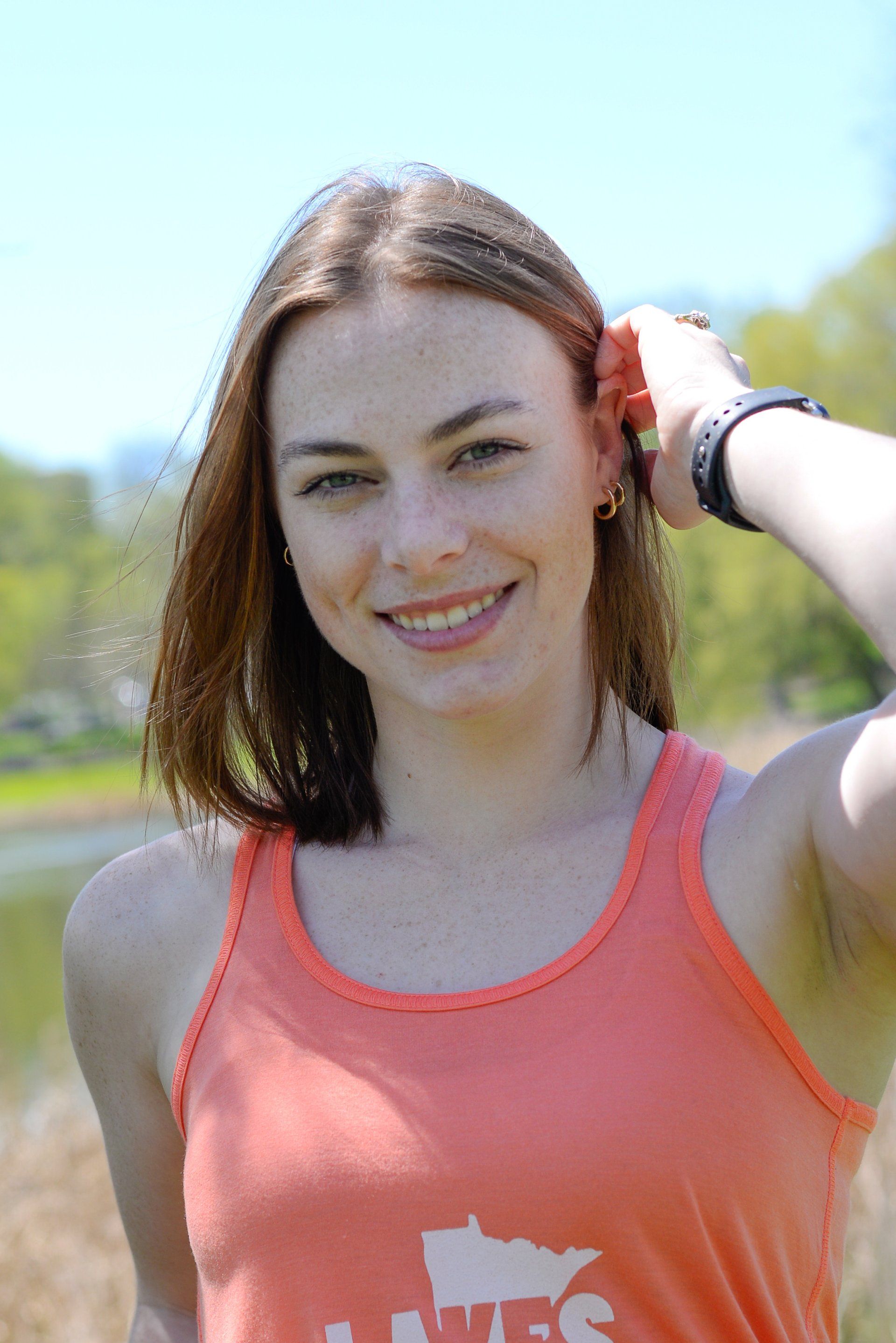A woman wearing an orange tank top with the word minnesota on it