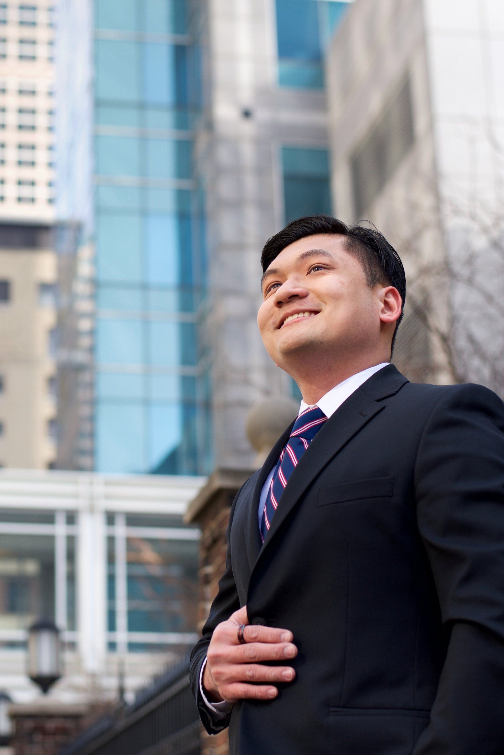 A man in a suit and tie is standing in front of a building