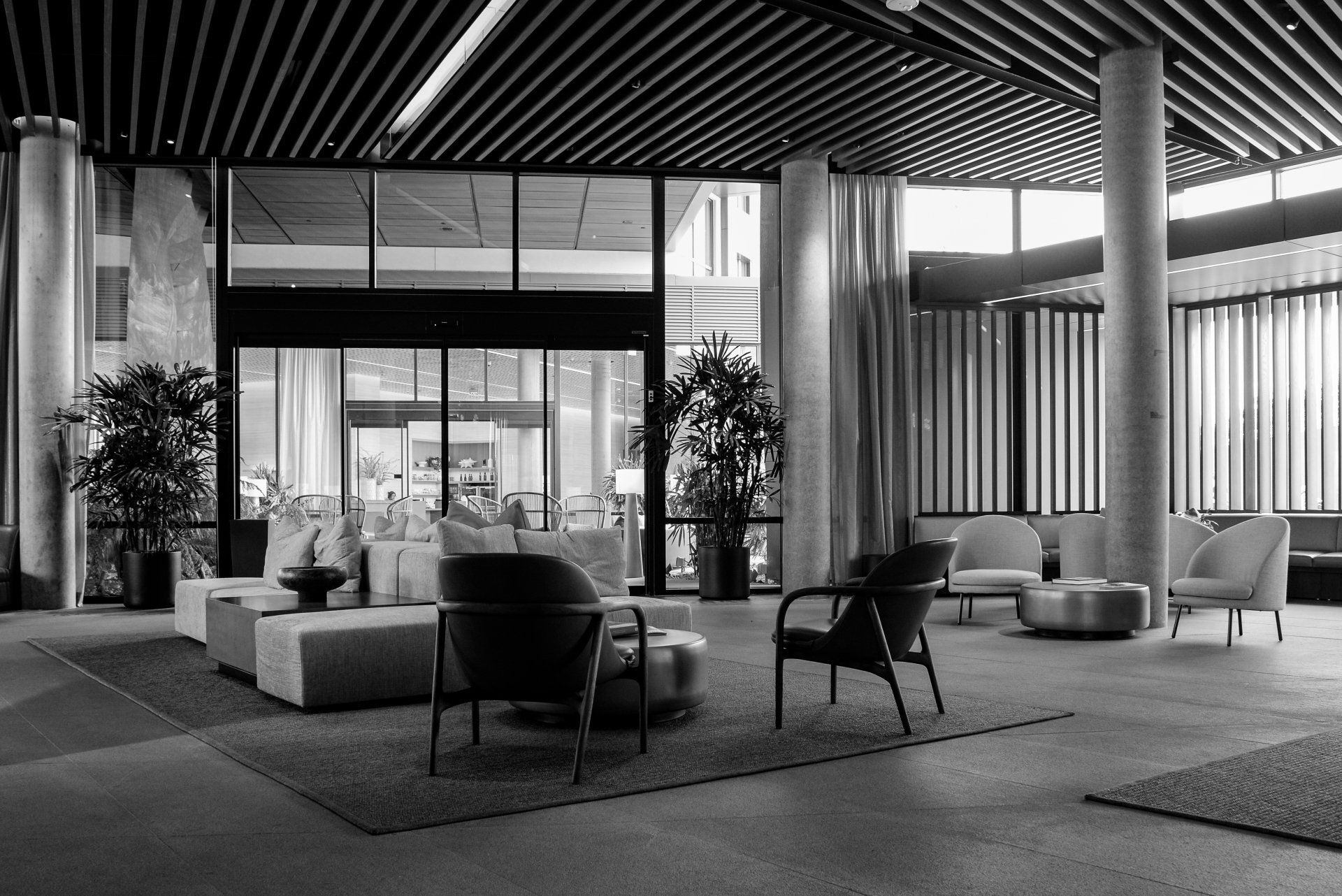 A black and white photo of a lobby with a lot of furniture