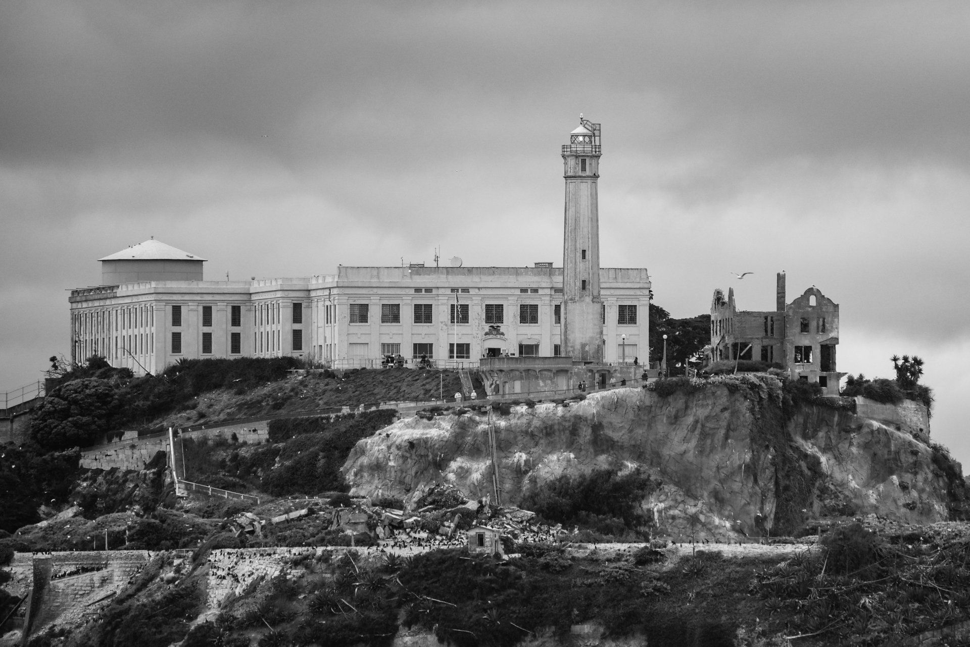 A black and white photo of a large building on top of a hill