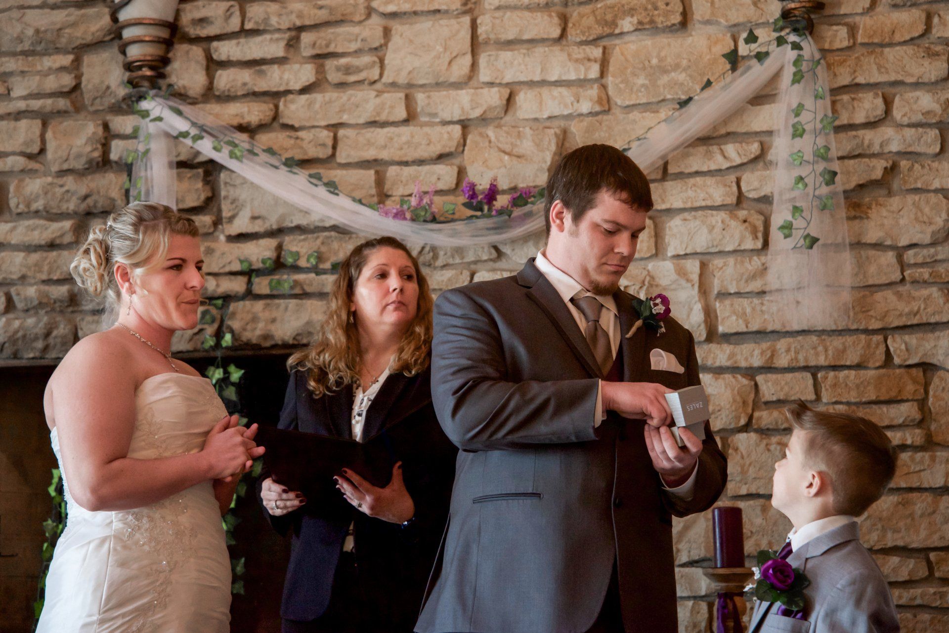 A bride and groom are getting married in front of a stone fireplace