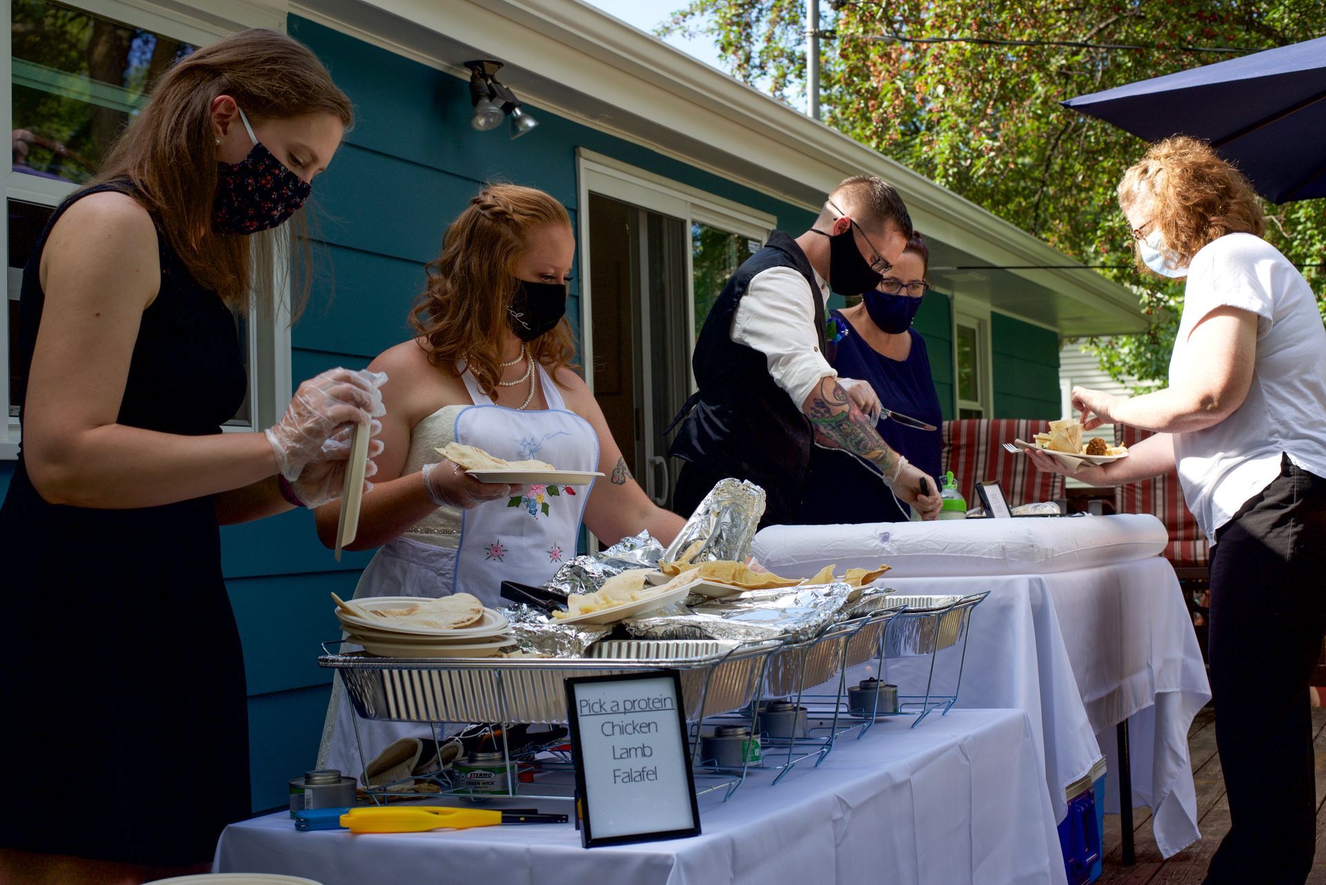 A group of people standing around a table with a sign that says 