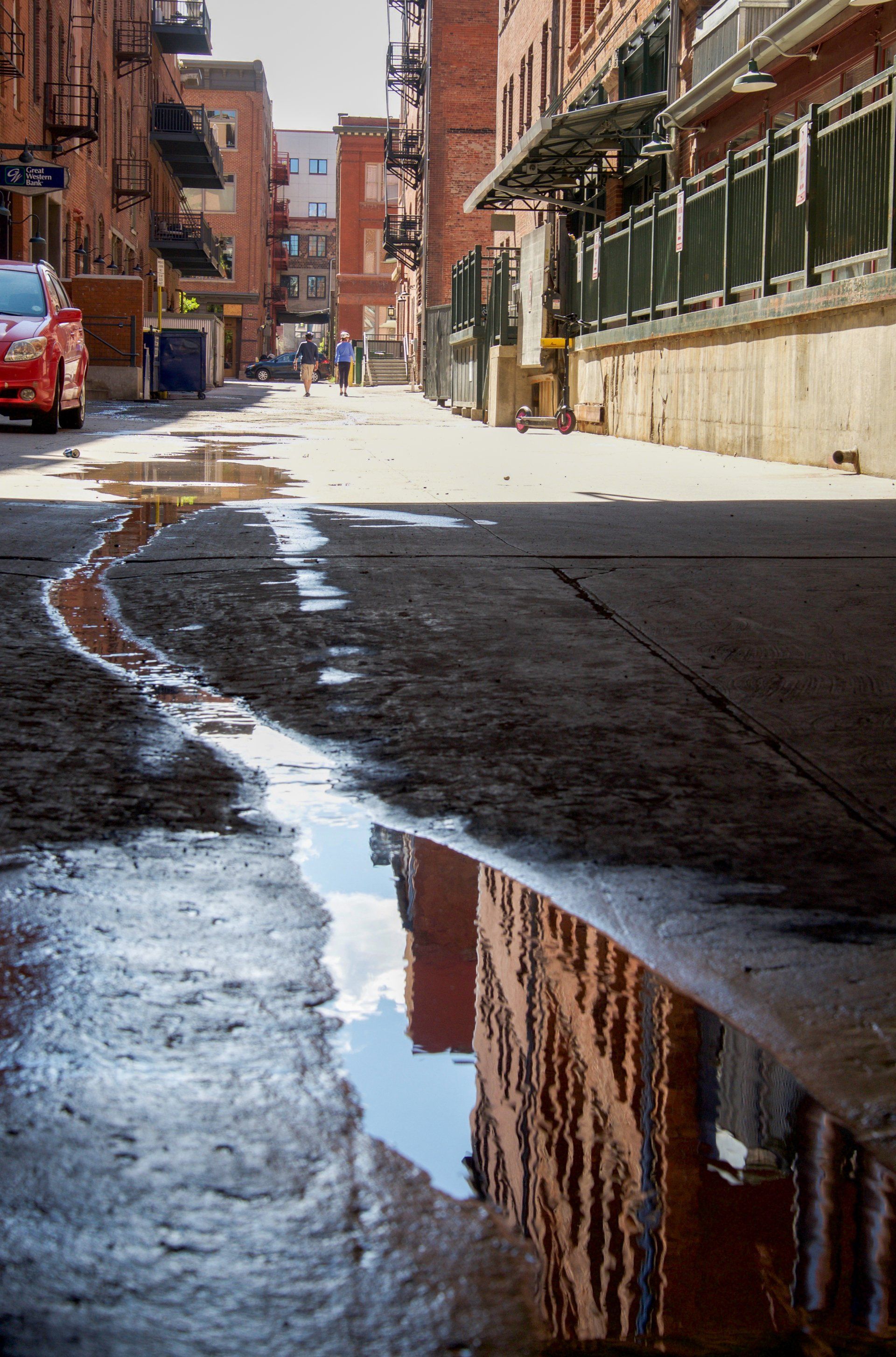 A reflection of a building in a puddle of water