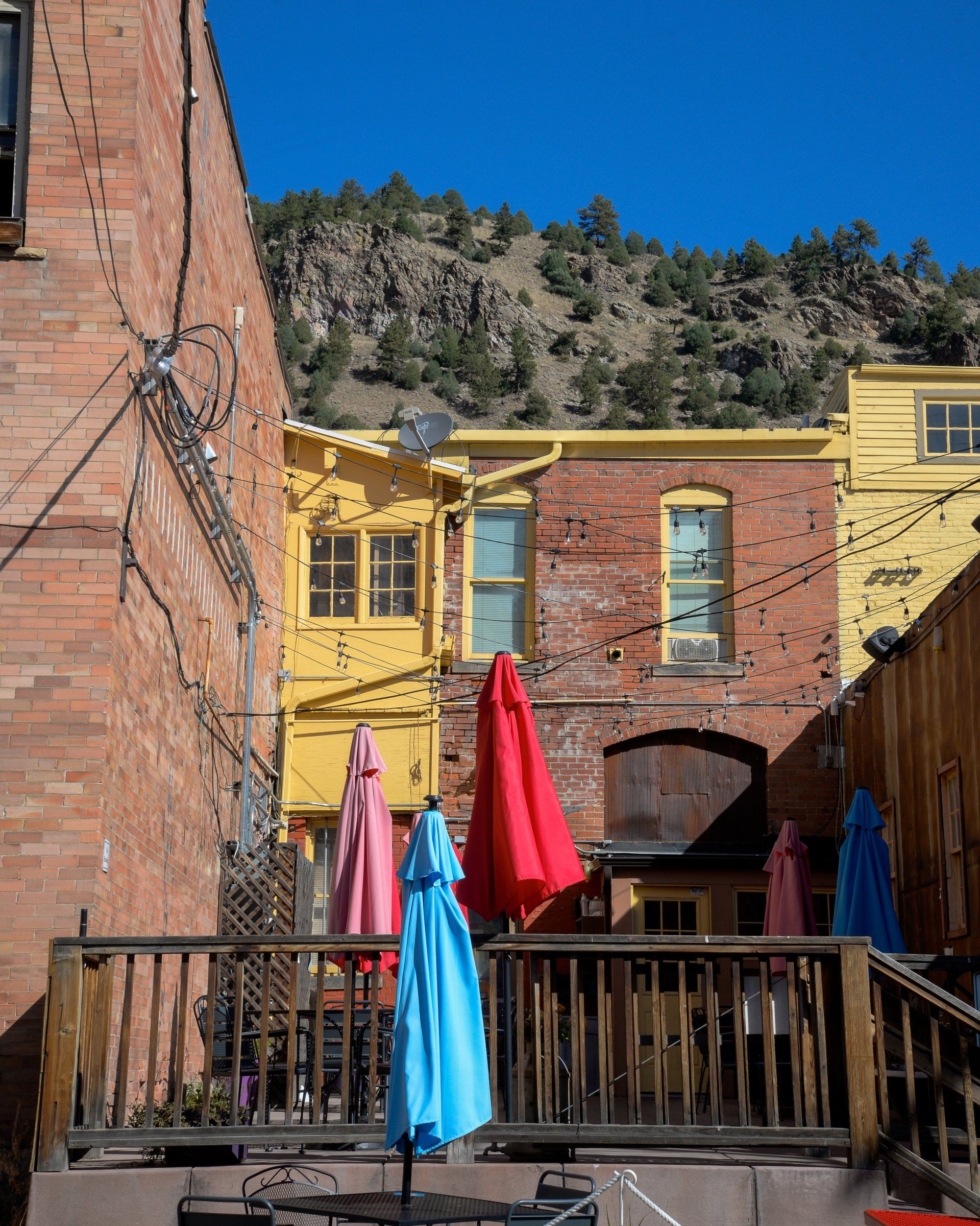 A balcony with umbrellas in front of a brick building