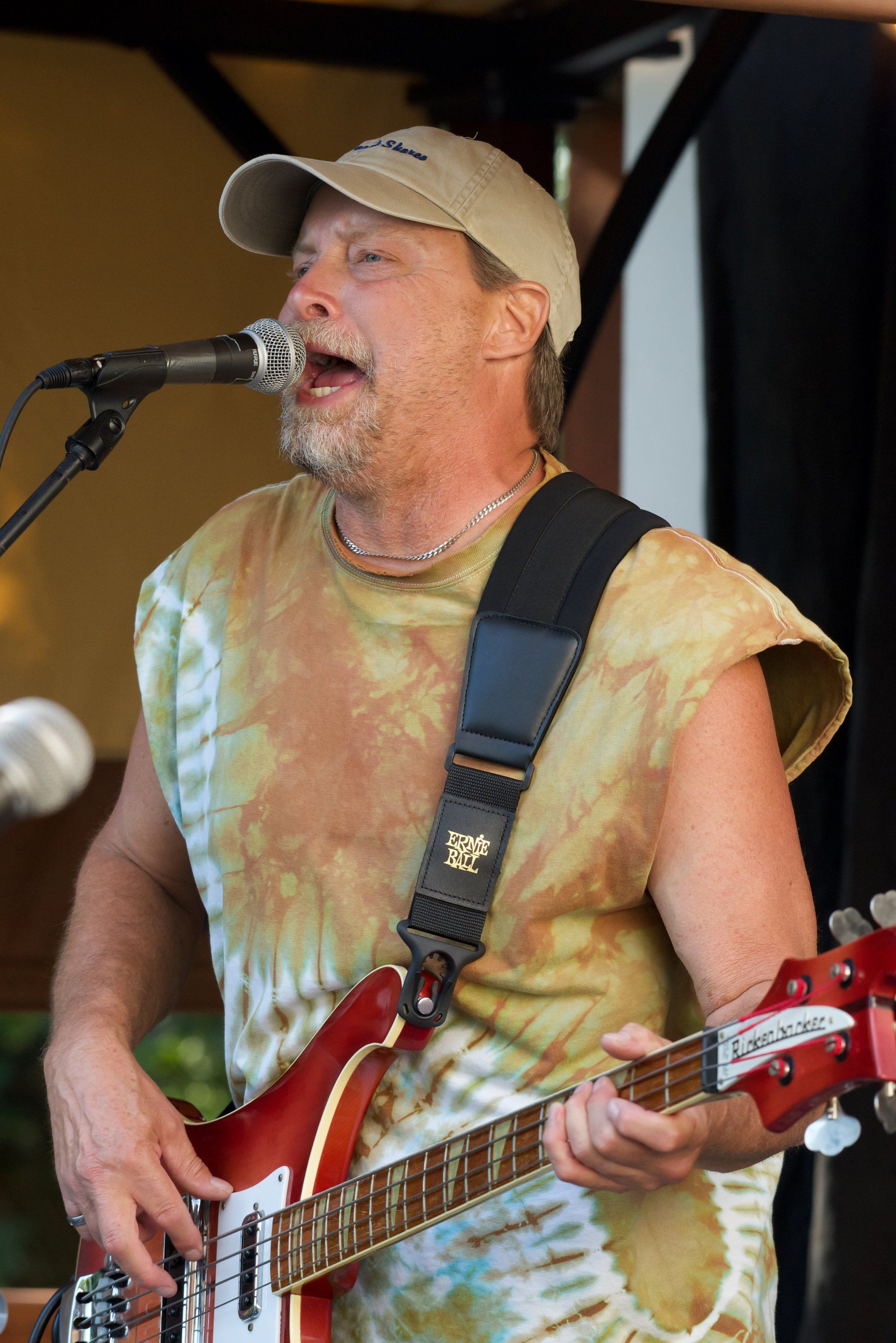 A man singing into a microphone while holding a guitar