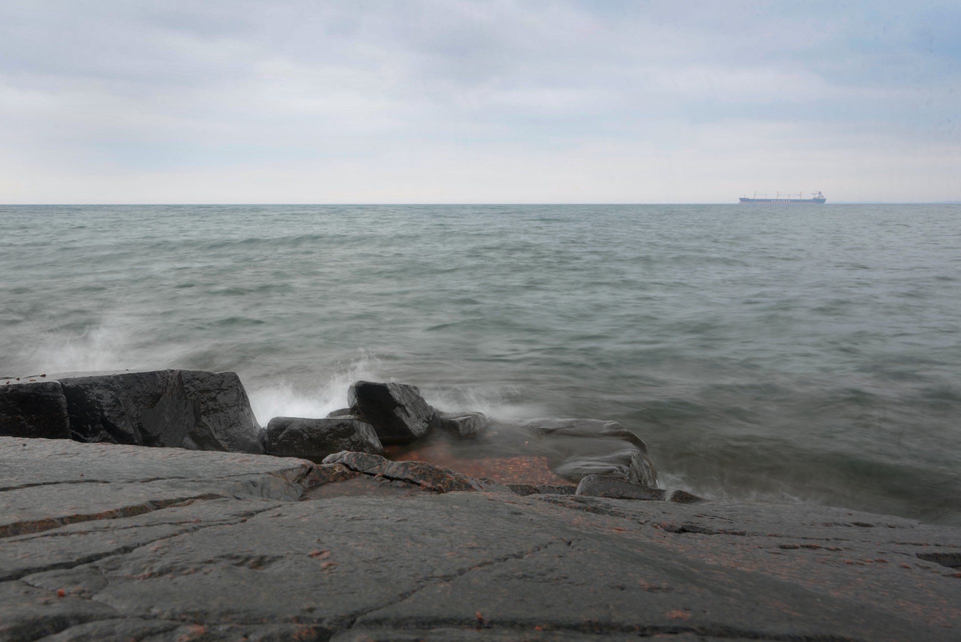 A large body of water is surrounded by rocks on a cloudy day.