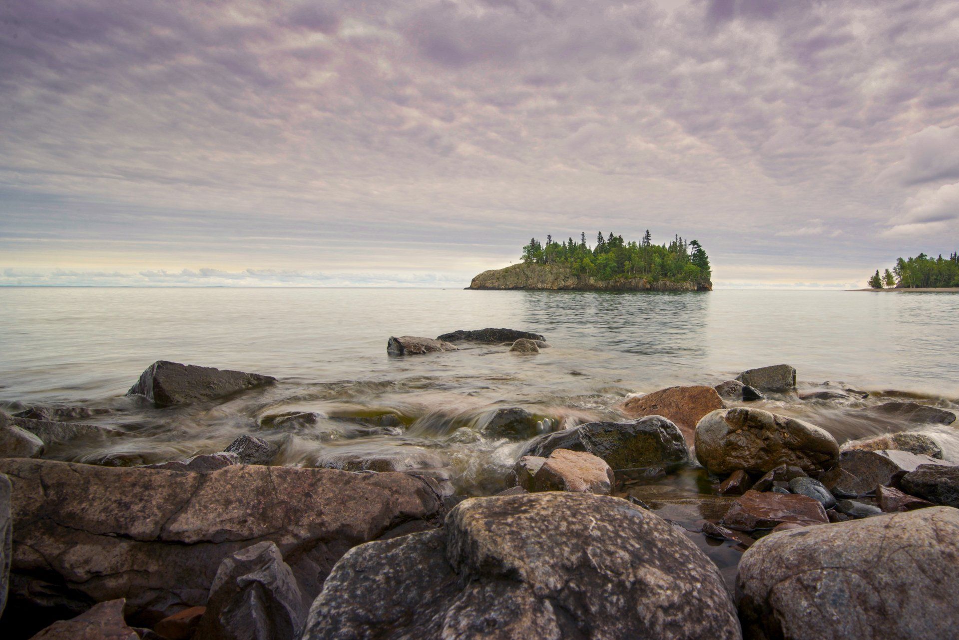 A small island in the middle of a large body of water