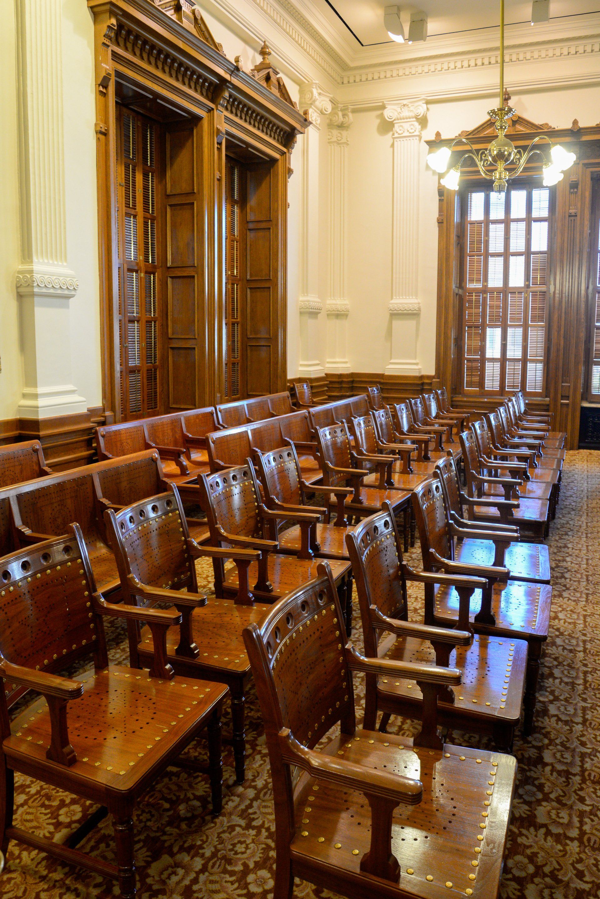 Rows of wooden chairs are lined up in a large room