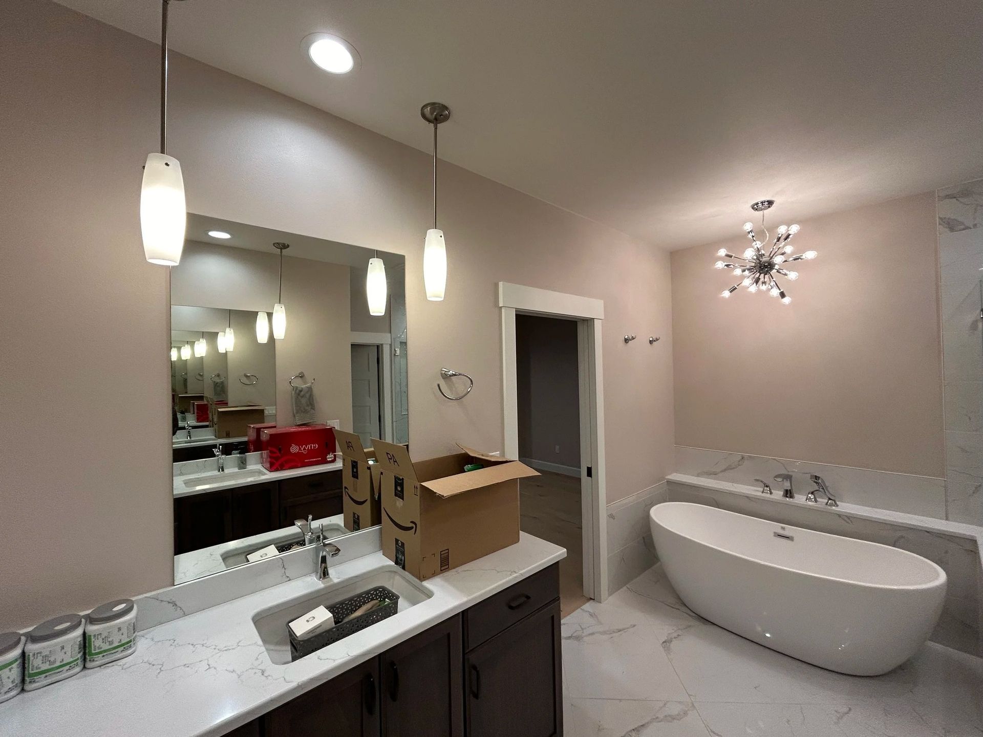 Bathroom with a freestanding tub, vanity, and overhead lighting.