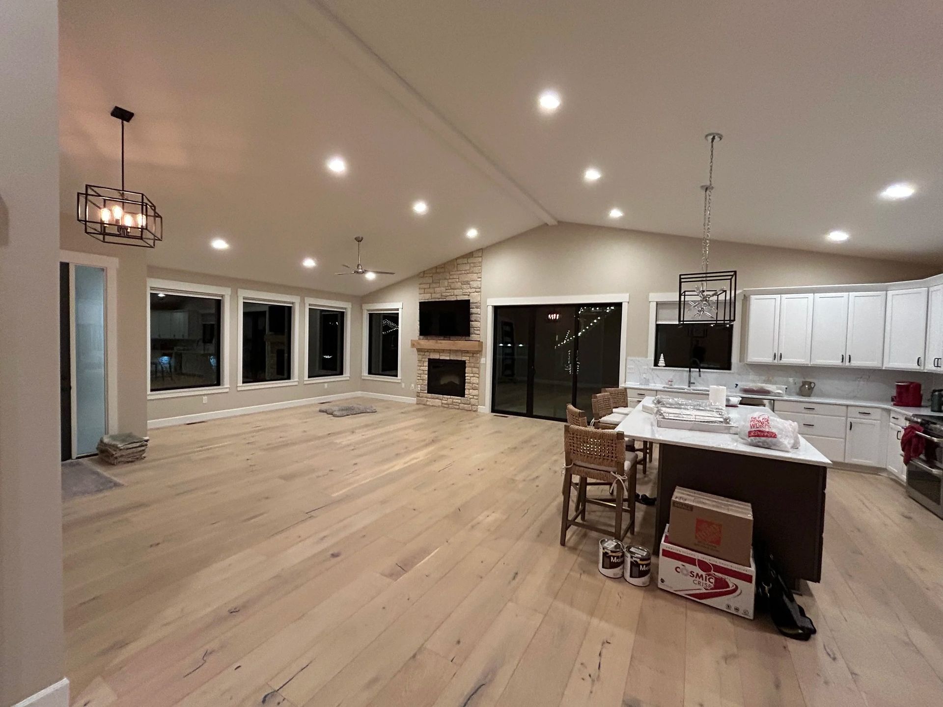 Spacious, newly remodeled room with light wood floors, recessed lighting, and a modern kitchen island.
