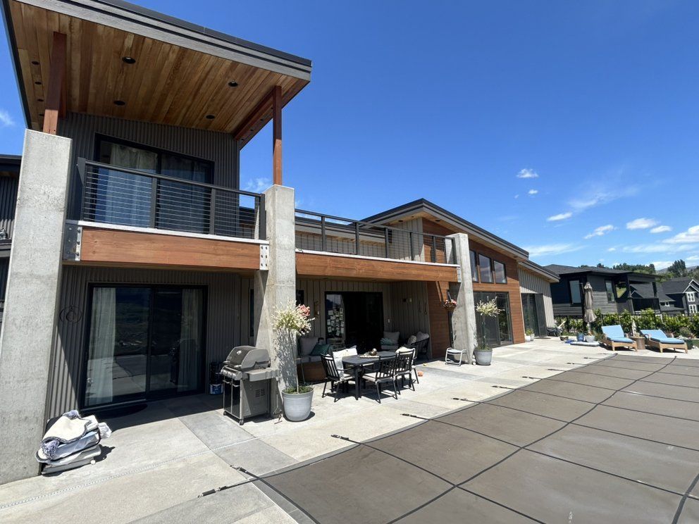 Modern home with a pool and patio on a sunny day.