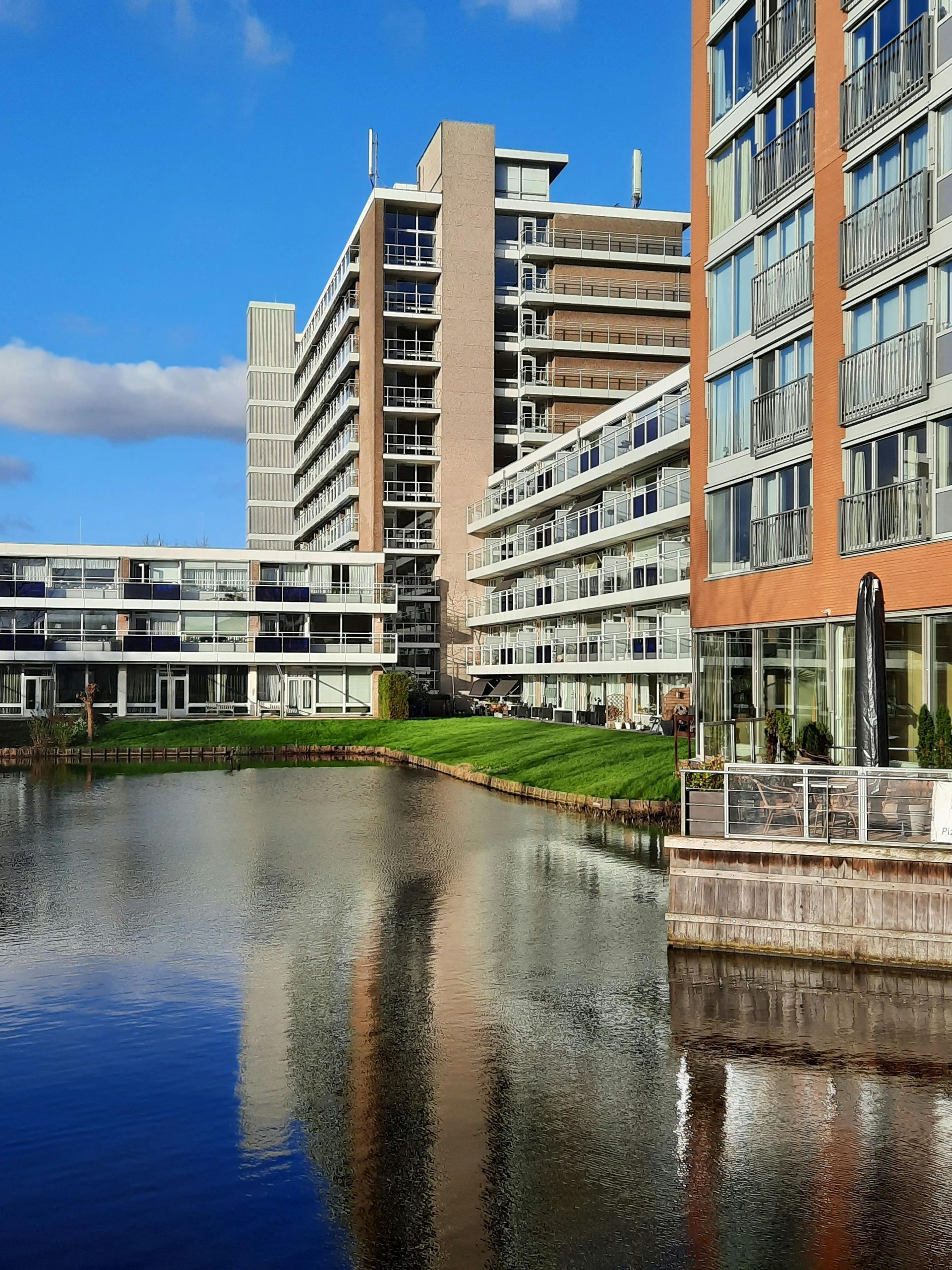 A row of tall buildings next to a body of water