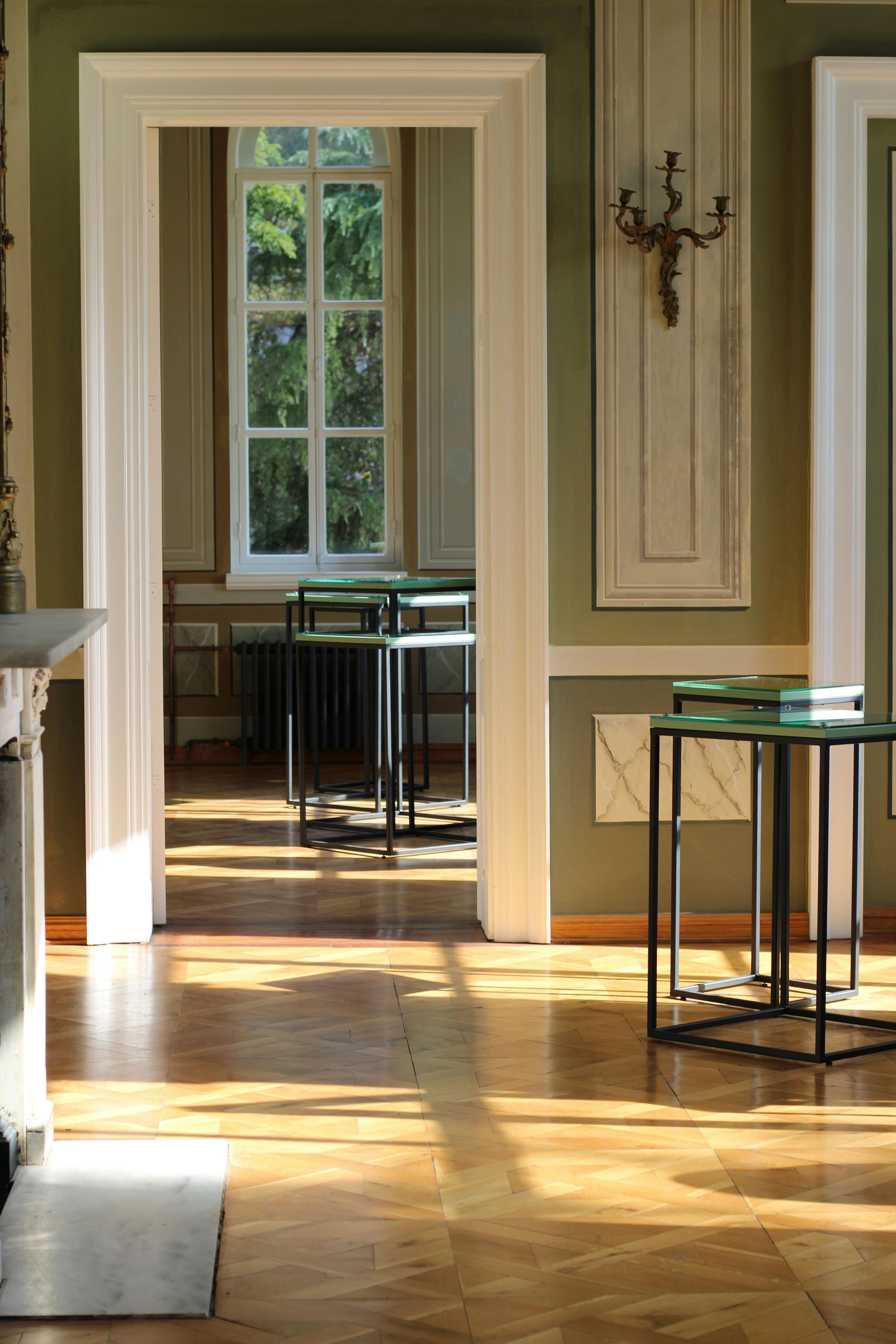 A living room with wooden floors , a fireplace , tables and chairs.