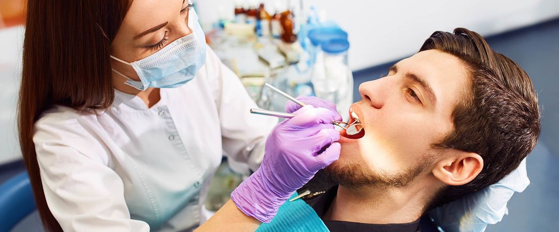 Un dentista che esamina il cavo orale di un paziente