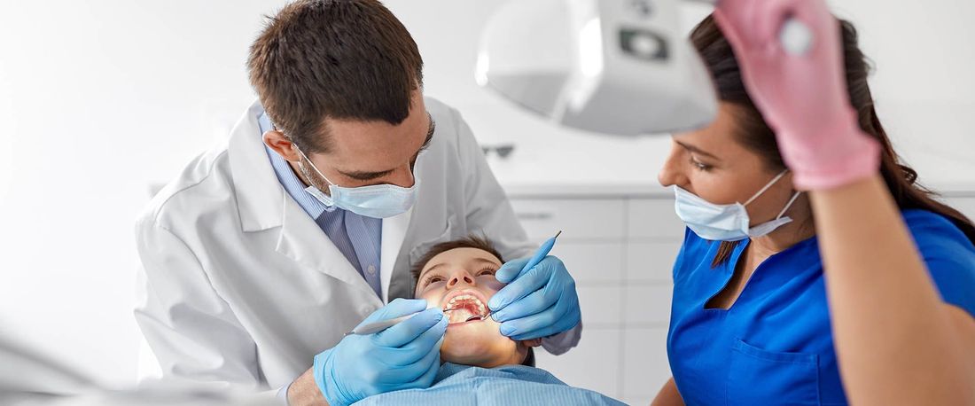 Un odontoiatra che visita la bocca di un paziente