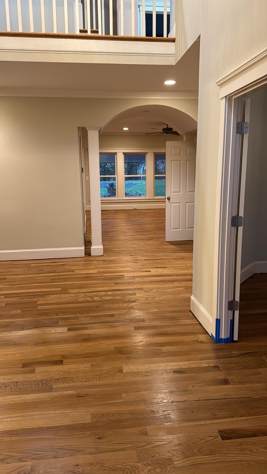 A large empty room with hardwood floors and white walls.