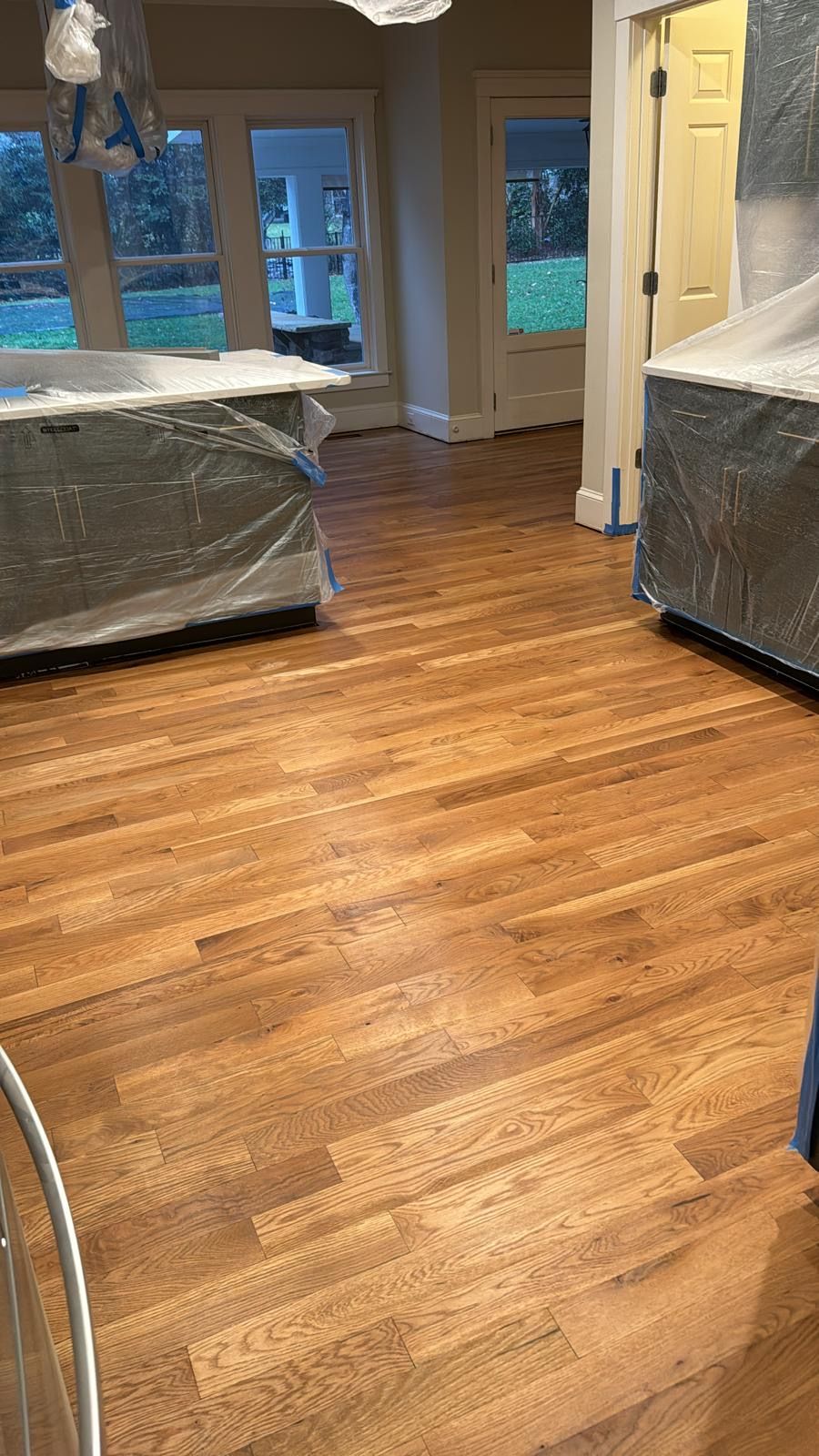 A wooden floor in a room with a lot of windows.
