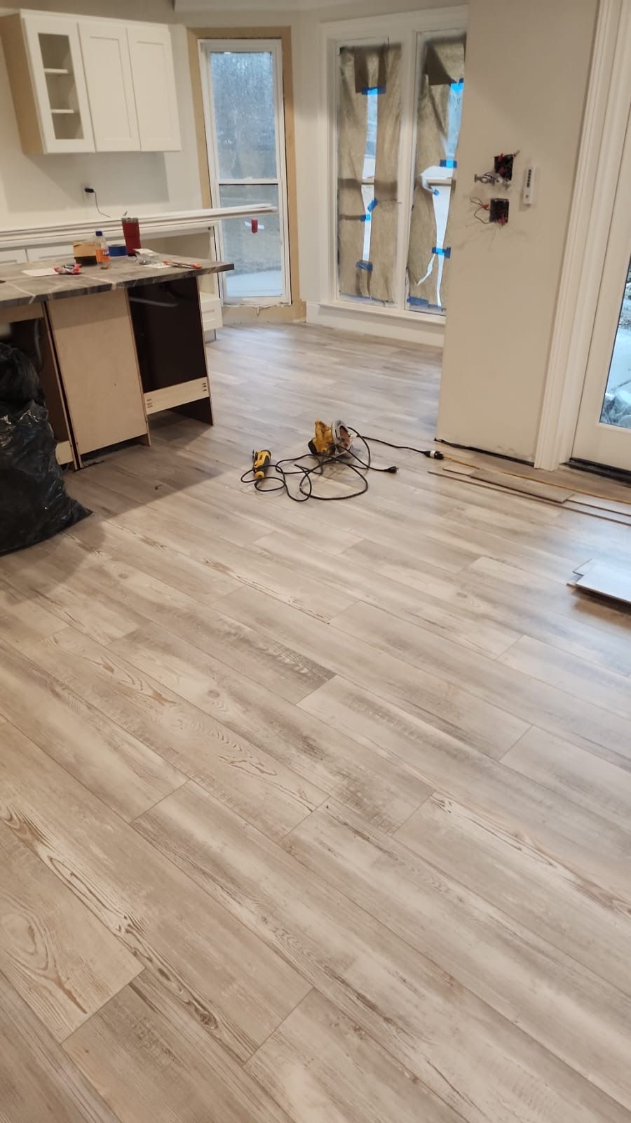 A kitchen with a wooden floor and a sliding glass door.