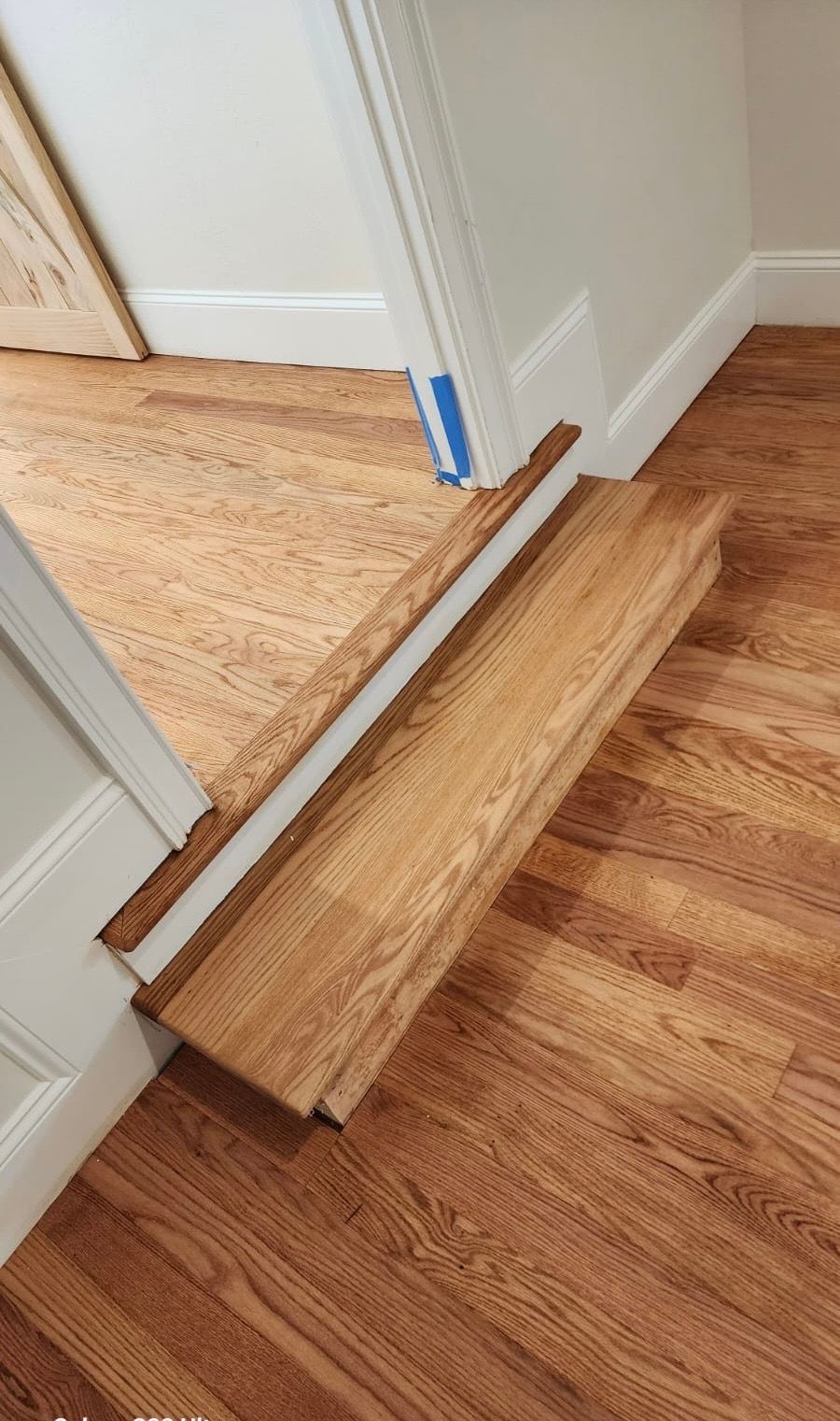 A wooden staircase leading up to a door in a house.