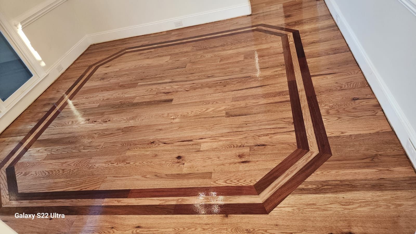 A wooden floor with a geometric design on it.