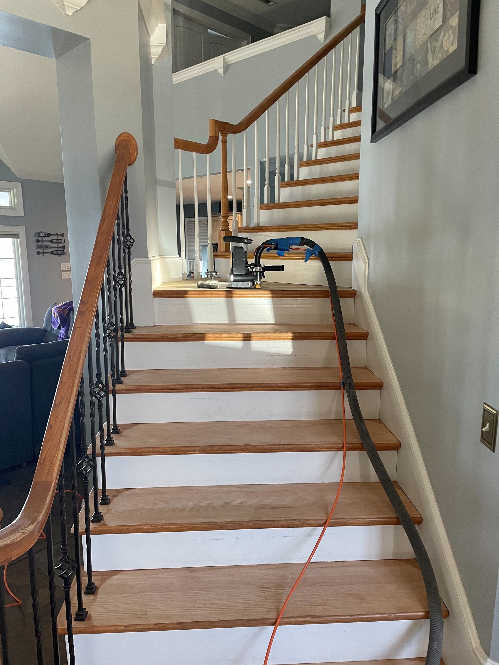 A staircase with a vacuum hose attached to it
