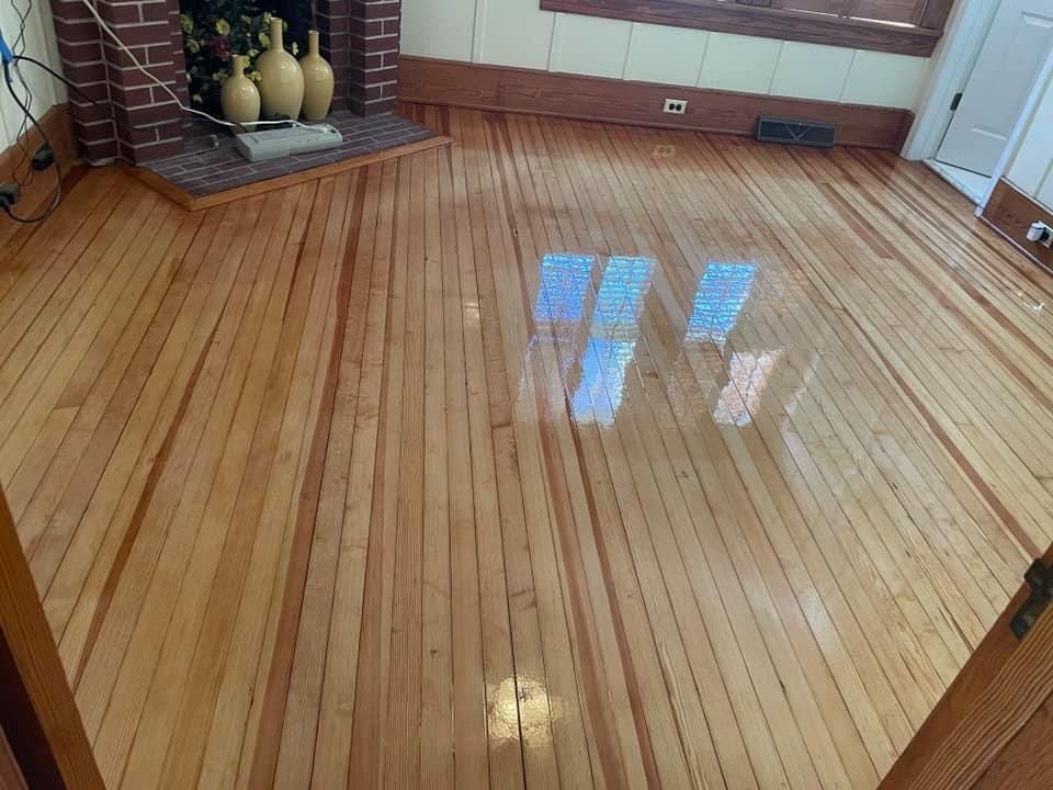 A living room with a wooden floor and a fireplace.