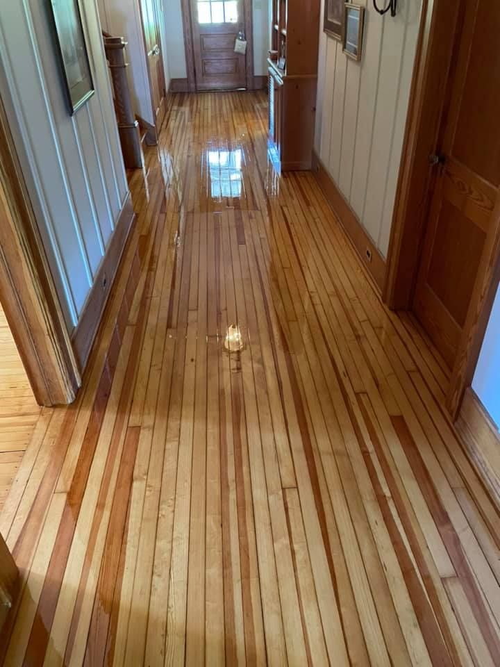 A hallway with a wooden floor and a candle on it.