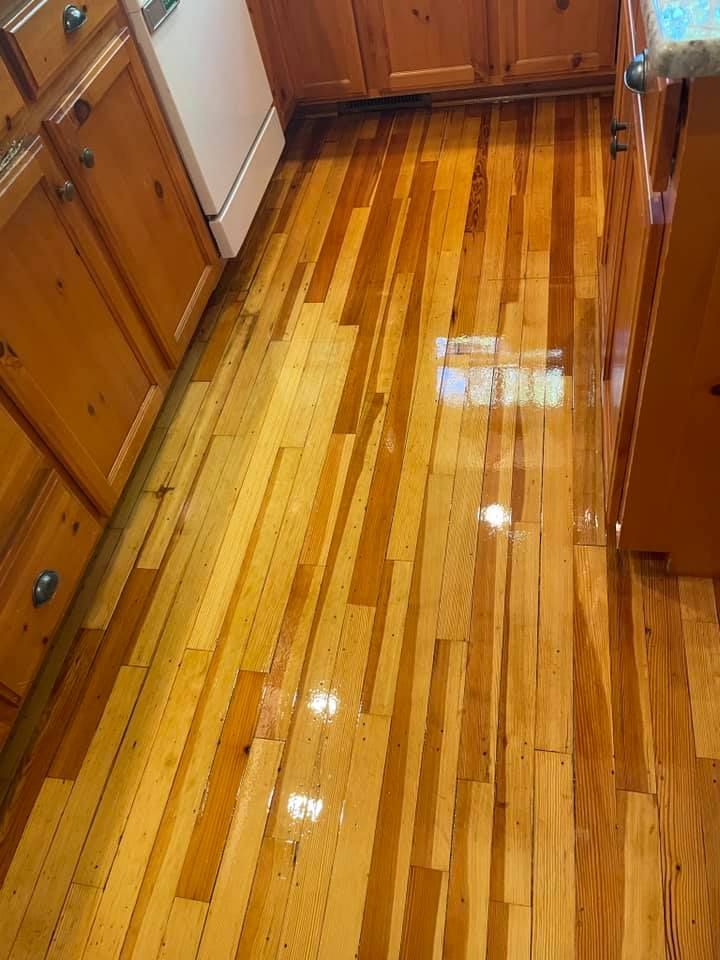A kitchen with a wooden floor and cabinets.